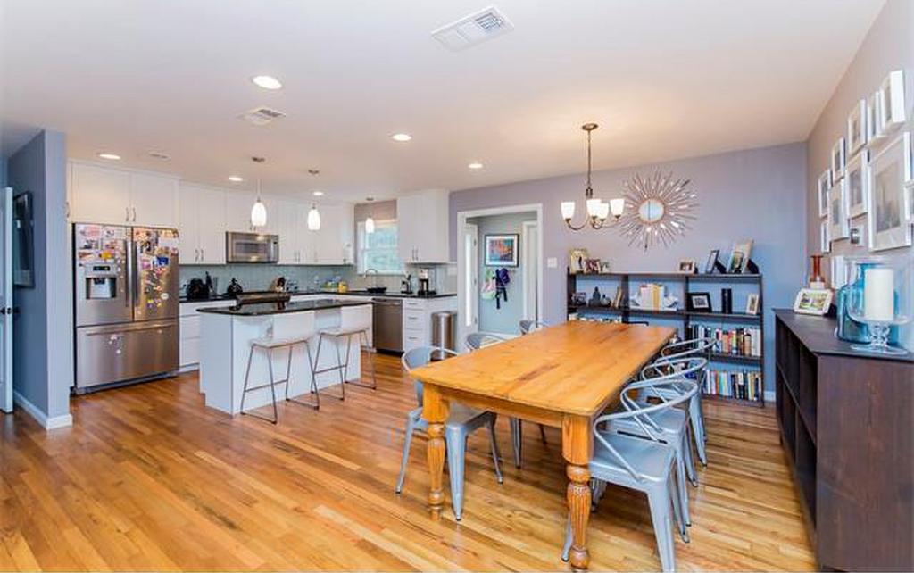 A large open-plan kitchen and dining space with contemporary but mostly traditional furnishings and lots of light blue accents