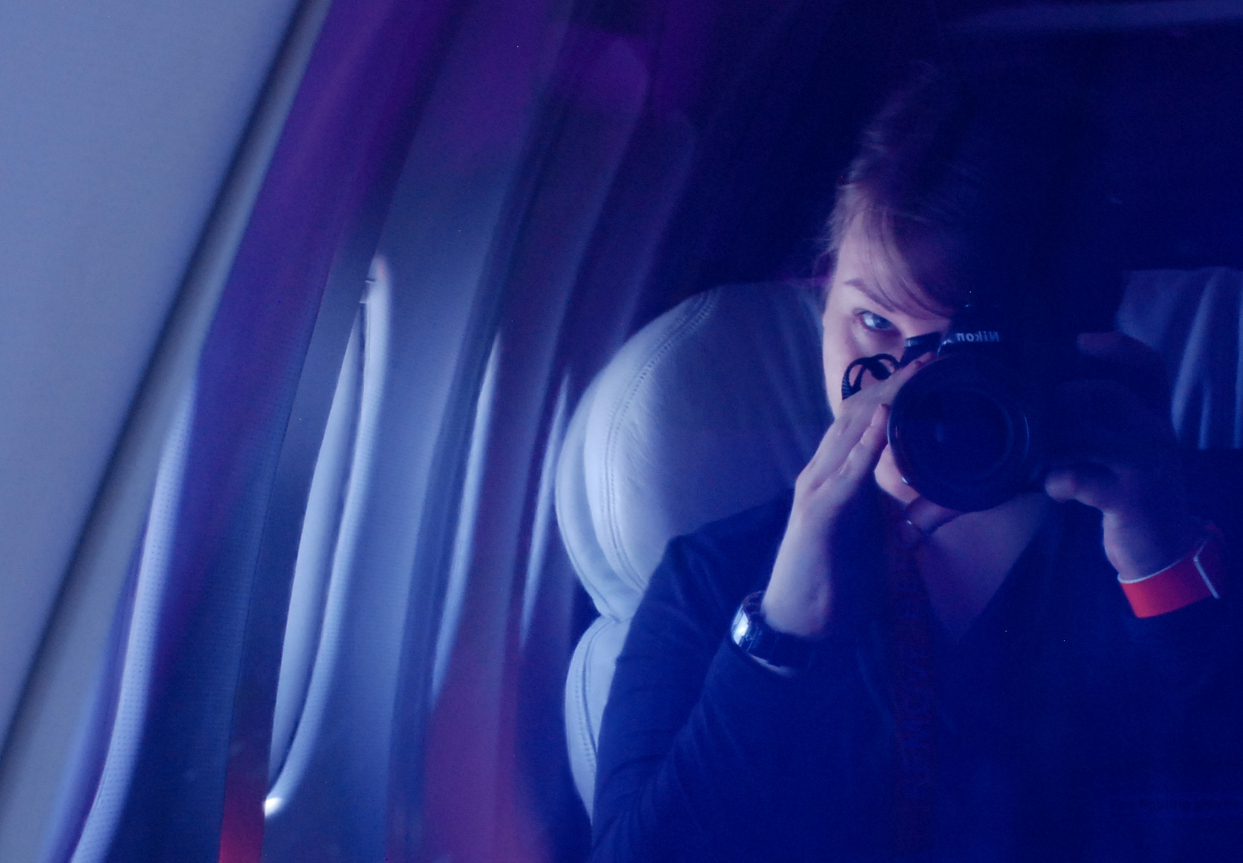 Travel writer Cynthia Drescher on a plane, holding a camera to her face