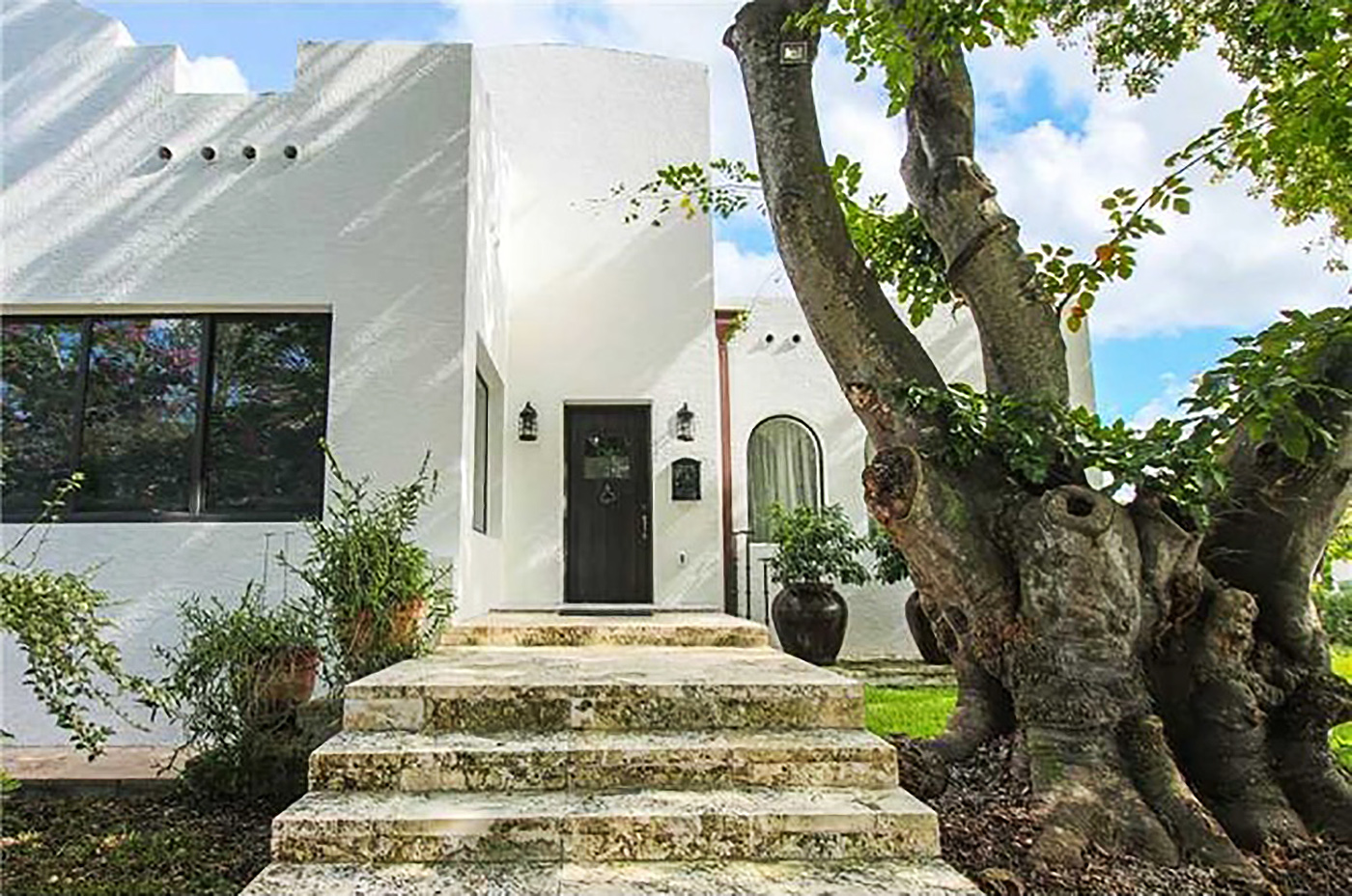 A Greek-looking home in Coral Way with white walls, and limestone steps