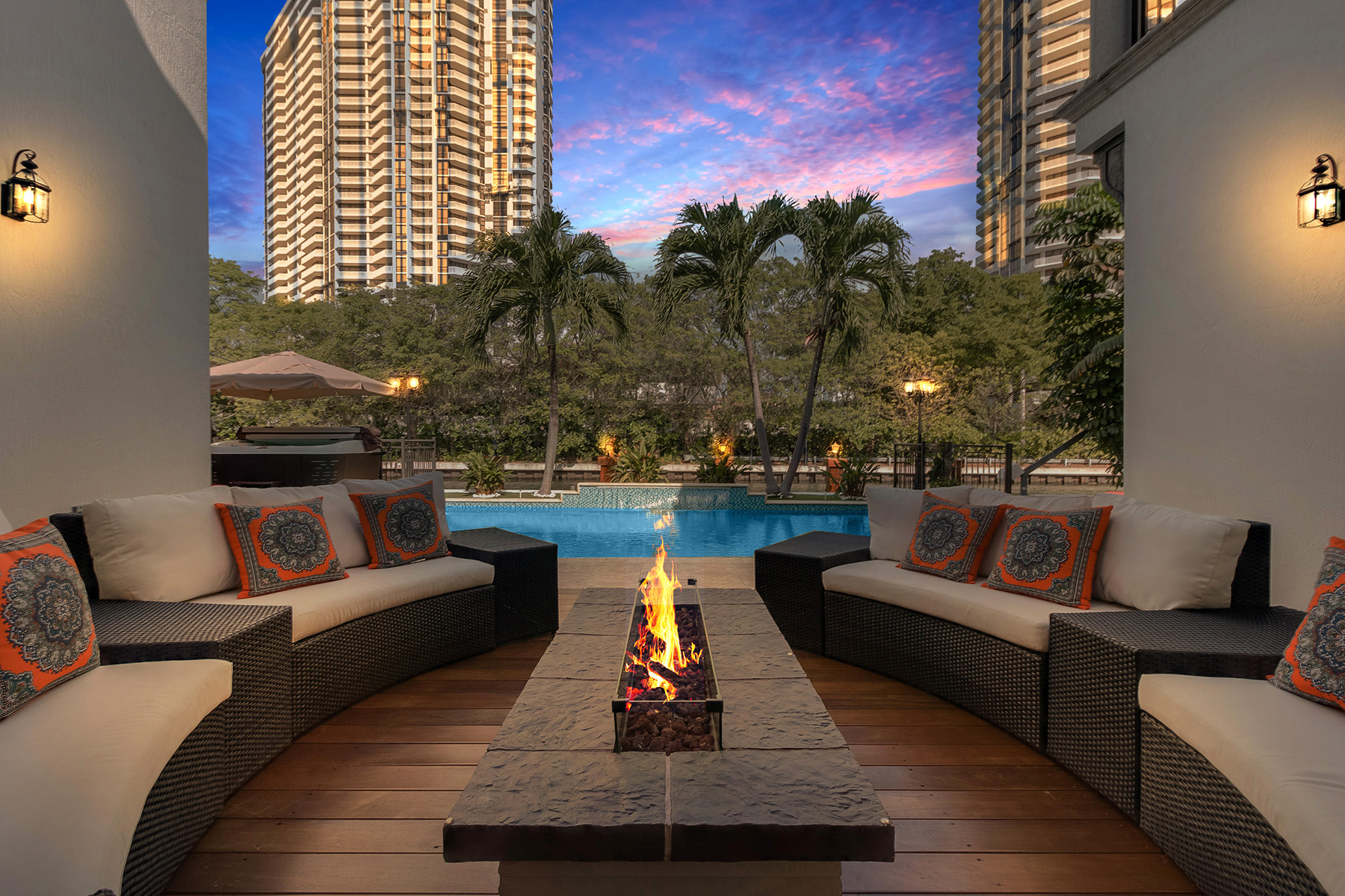A fire pit amid contemporary furniture by hte pool at a modern home in North Miami Beach