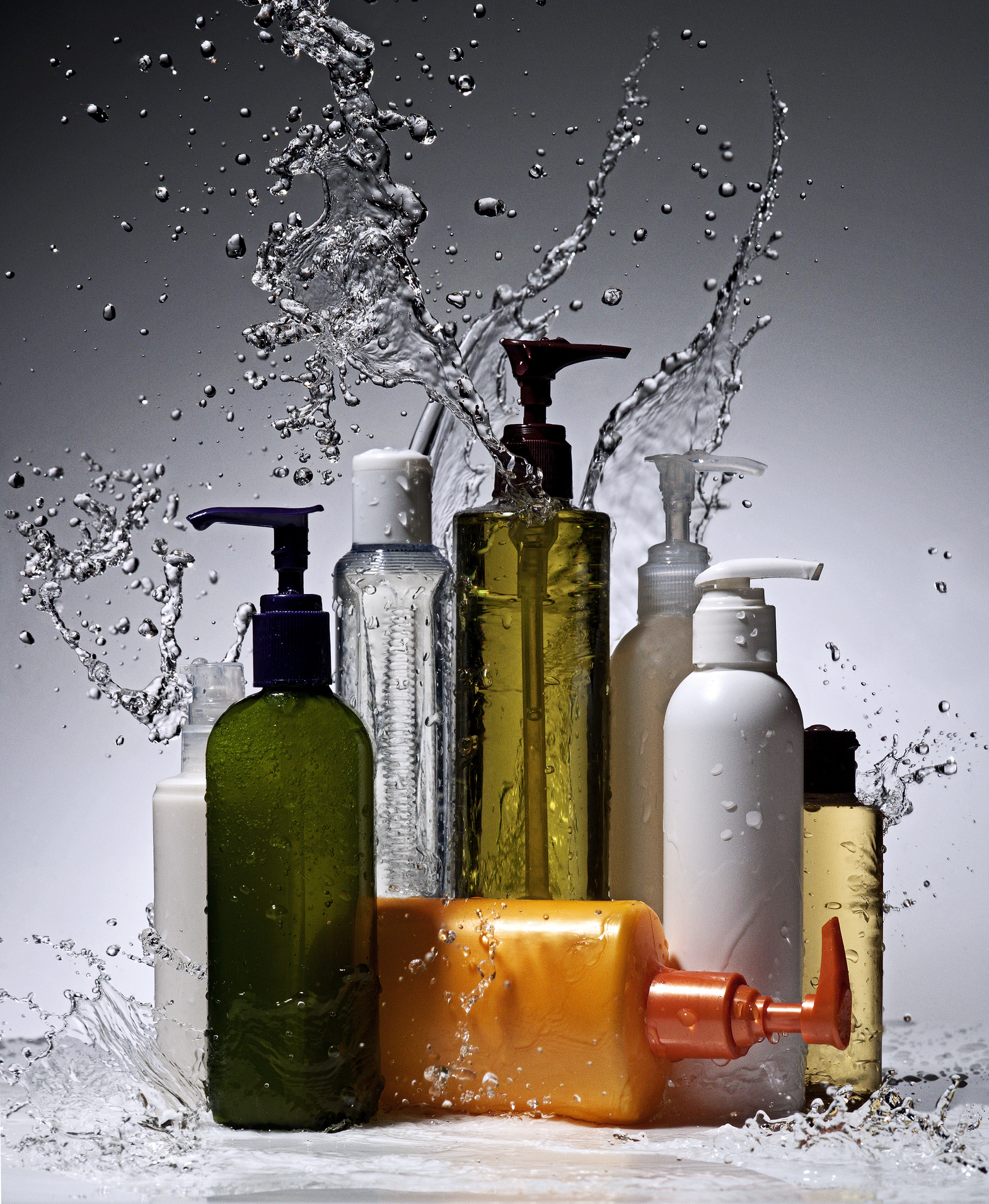 Skincare bottles set amid splashing water