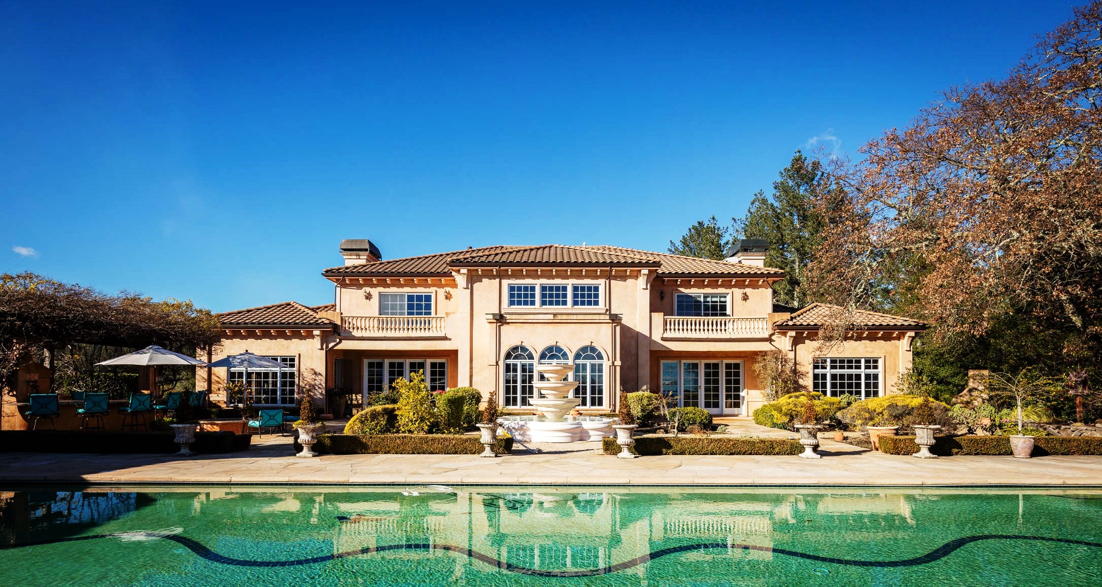 The facade of the sprawling estate house at 2900 Mountain Road, with a pool in front of it.