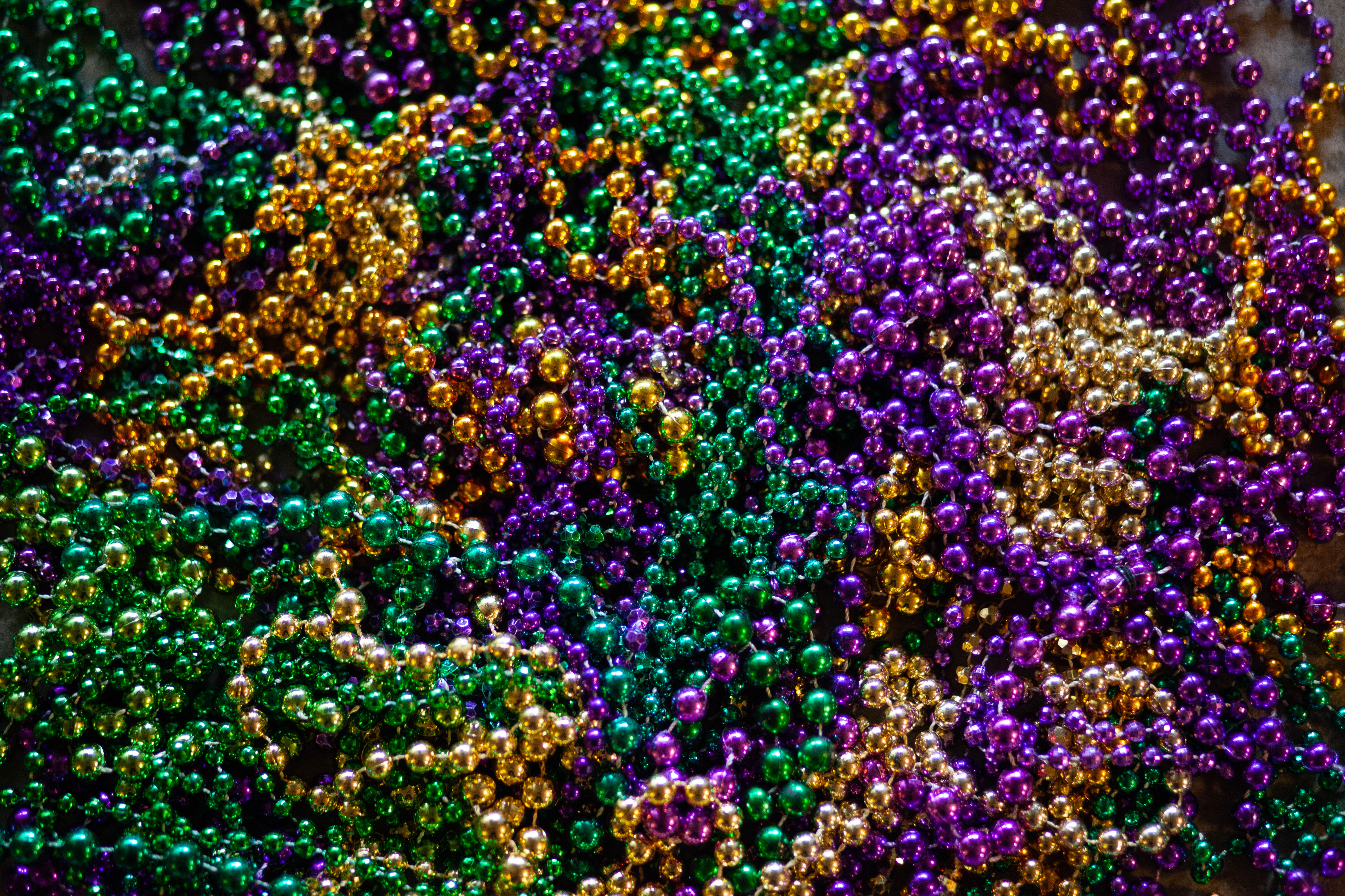 Green, yellow, and purple beaded necklaces in a pile.