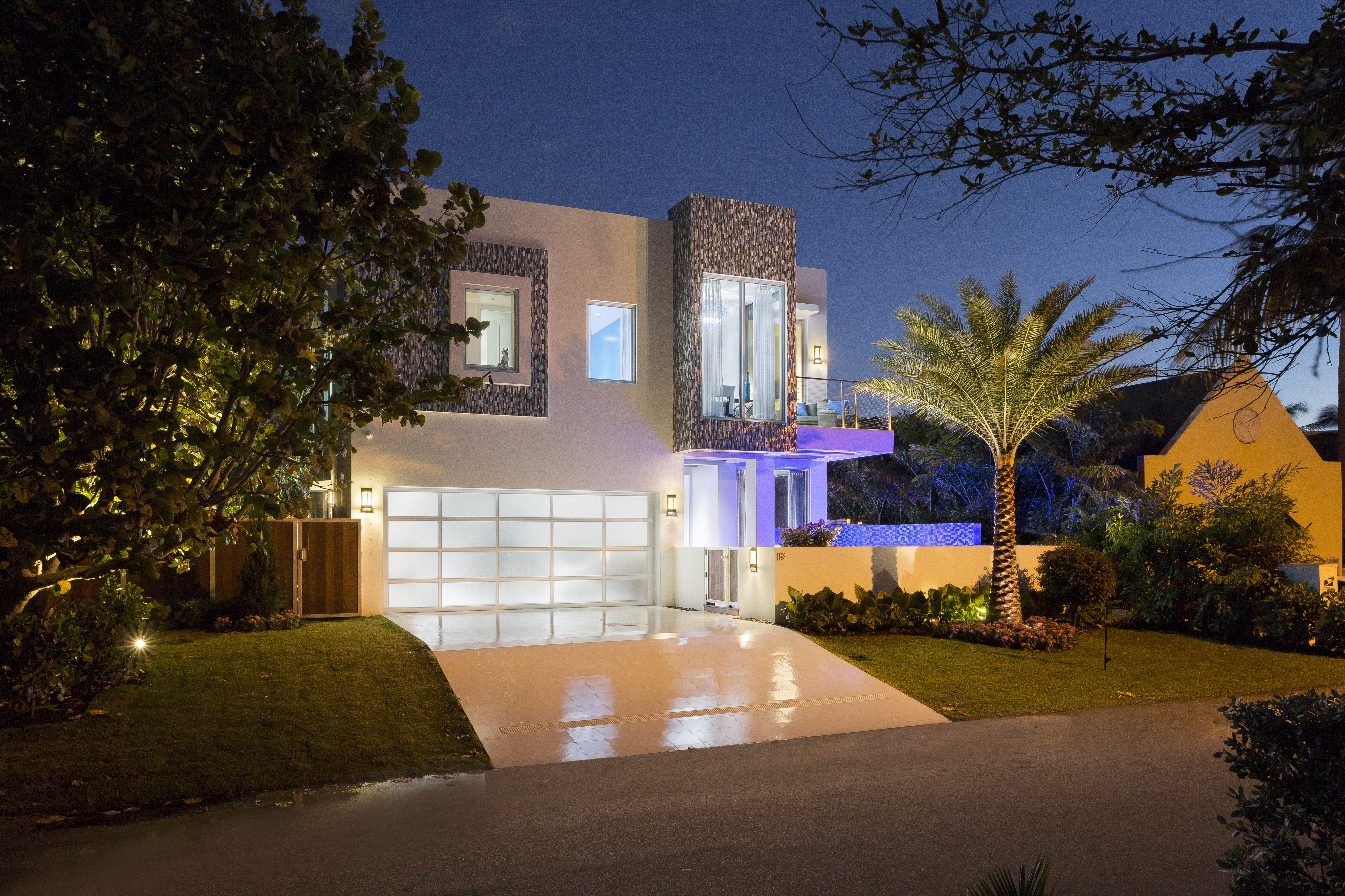 Modern micro mansion in Florida with neon lighting, multiple stories, and a garage door