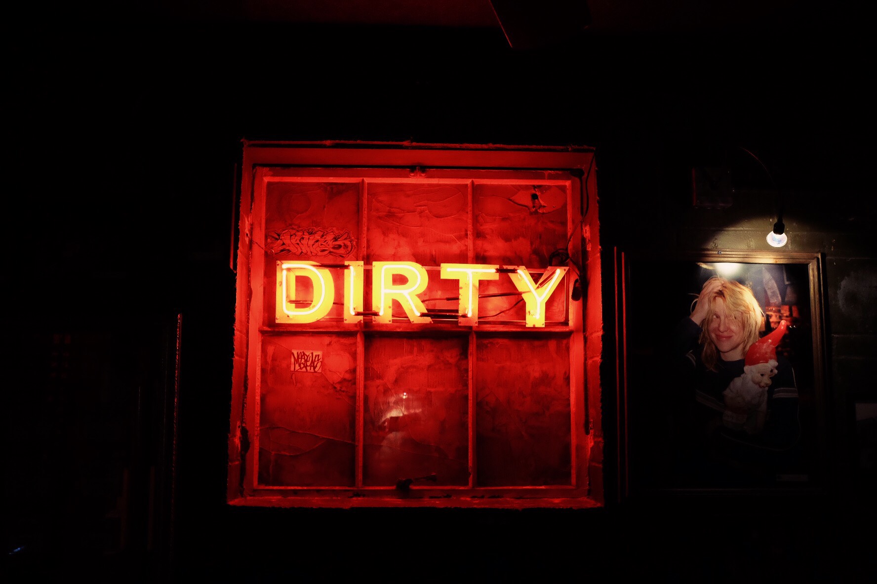 A lit-up neon sign that reads DIRTY.
