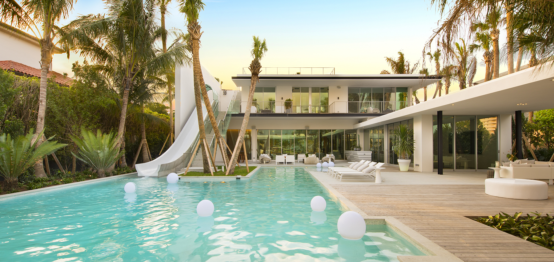 A Miami Beach spec mansion with a waterslide comprised of concrete into the pool.
