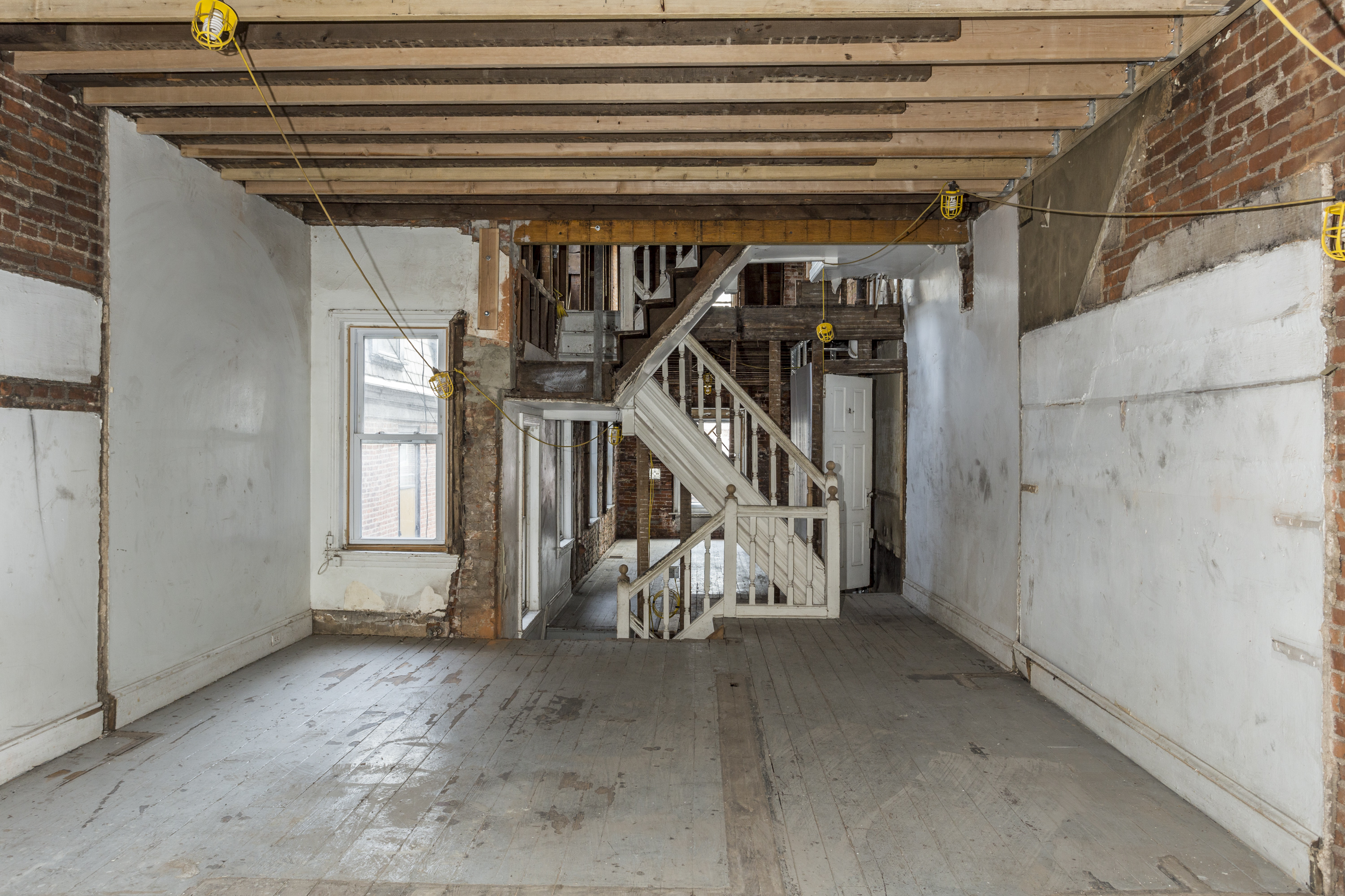 A completely gutted room with a staircase in the center.