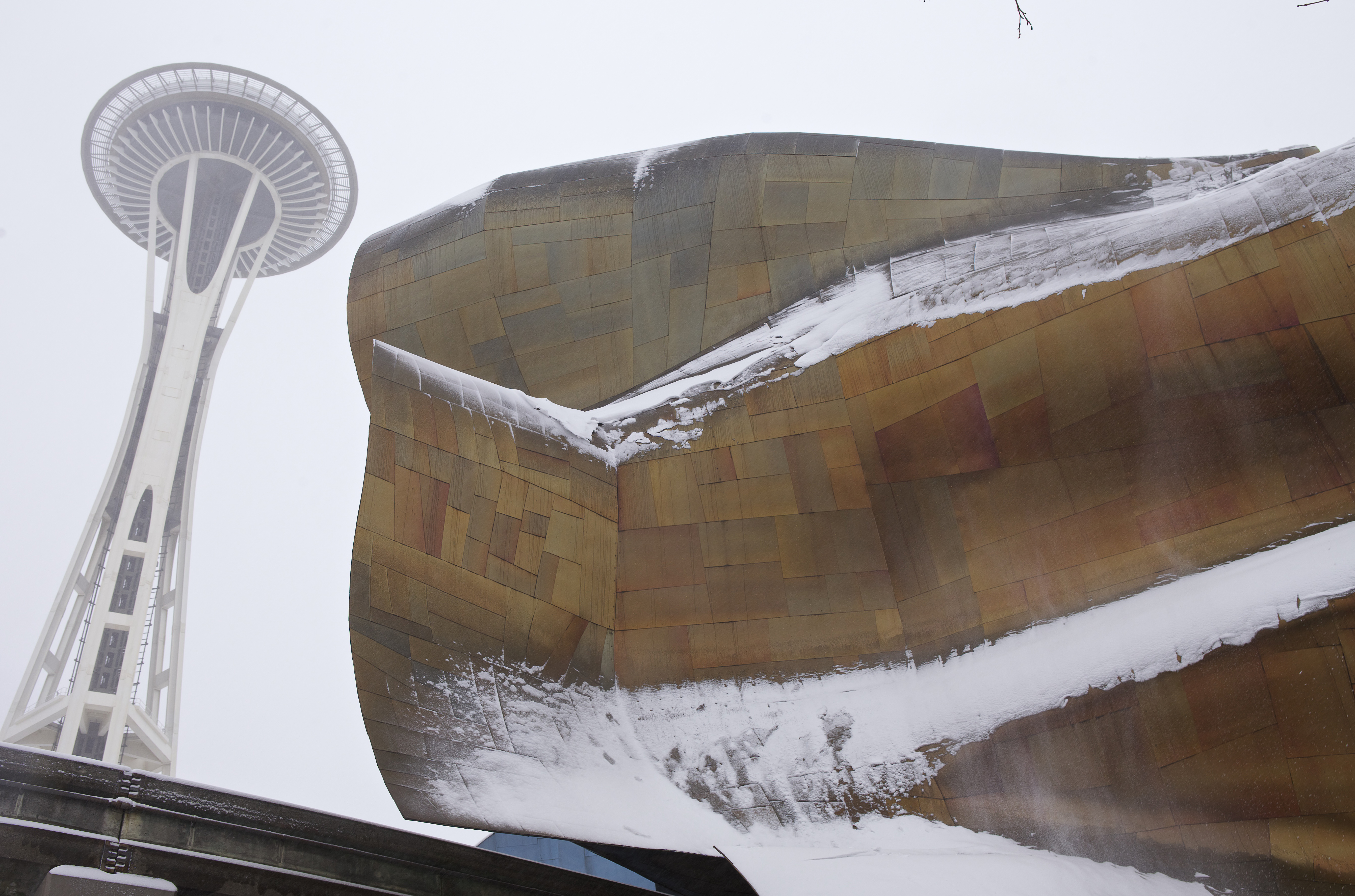 The Space Needle viewed from below, with EMP (a bendy wall of metal) in the foreground to the right