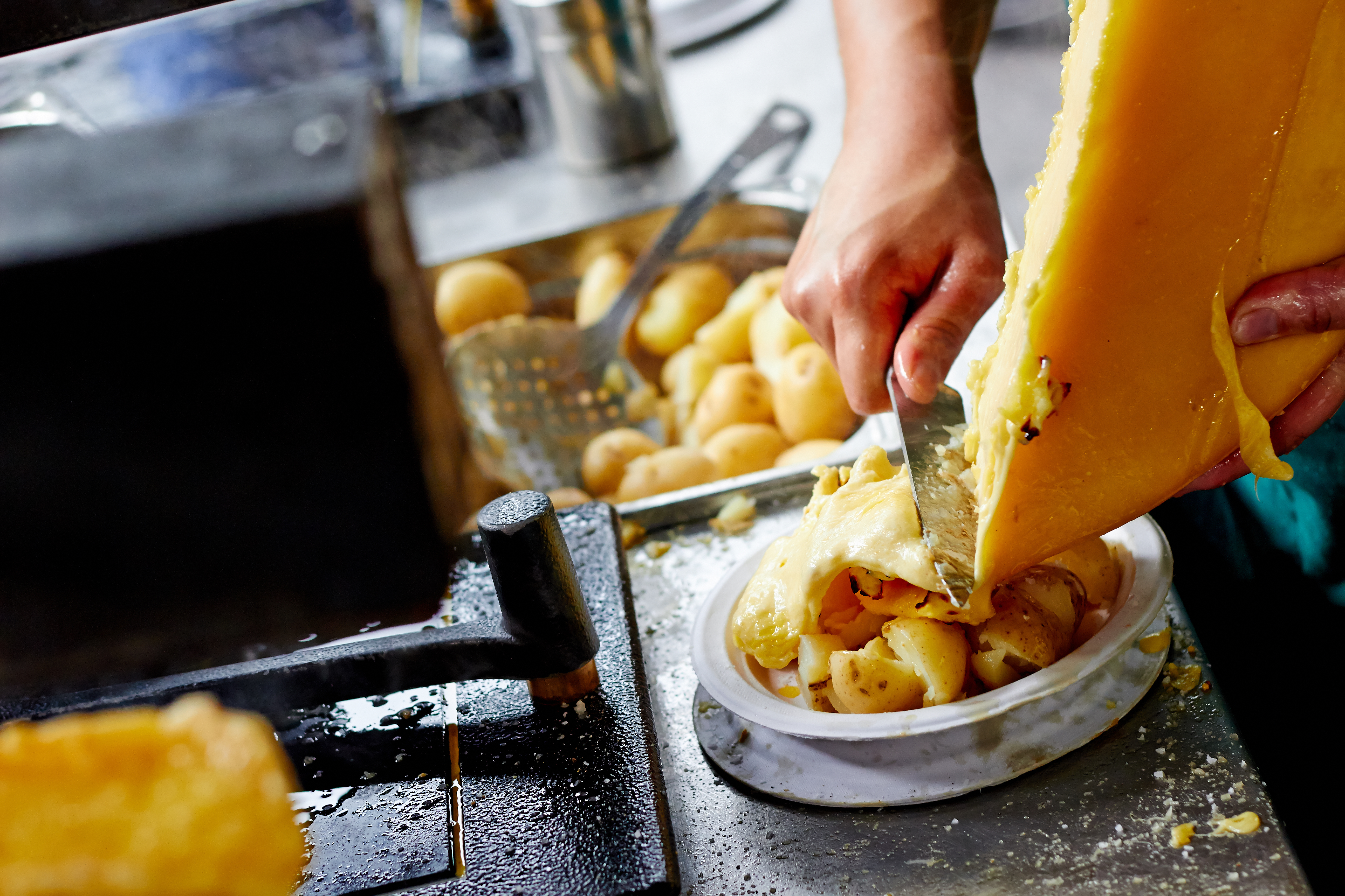 Raclette cheese scraped on top of potatoes at a London restaurant