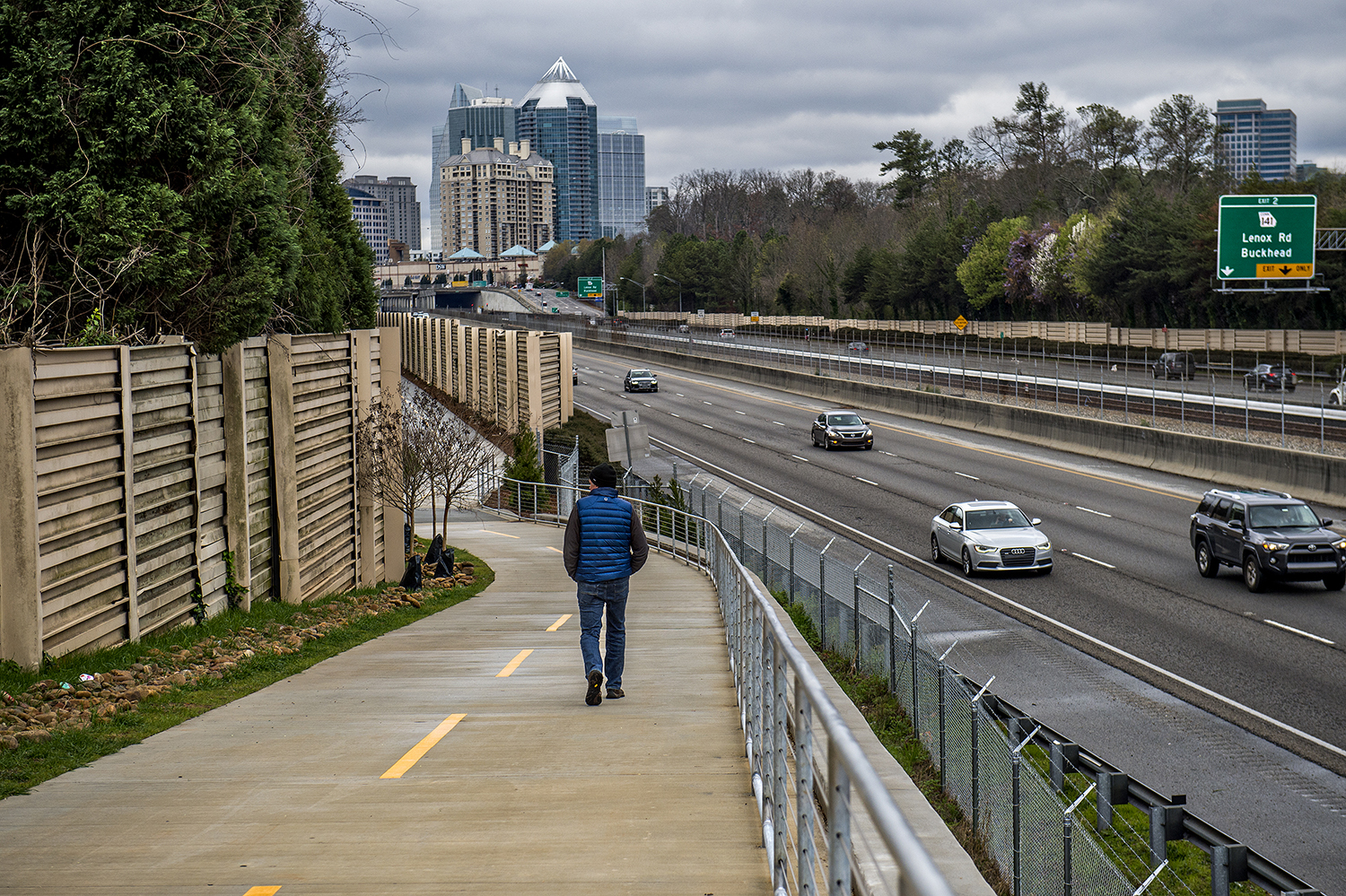 A man walks along PATH 400 in Buckhead in mid-March, chilly. 