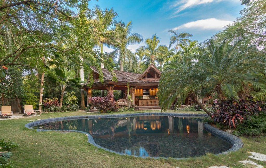 A wooden Key West home with tropical landscaping and a large pool