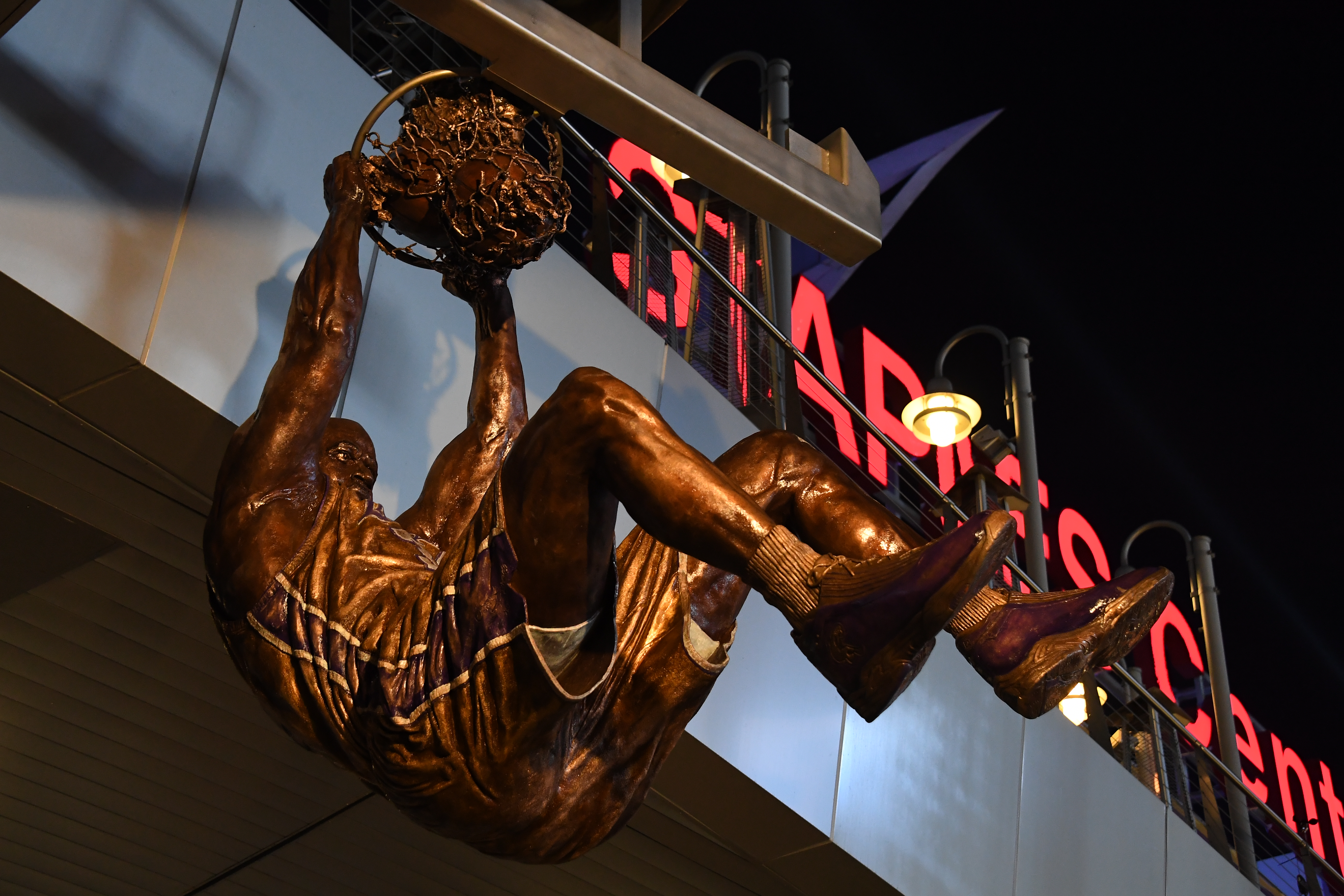 View looking up at statue with Staples Center sign in background