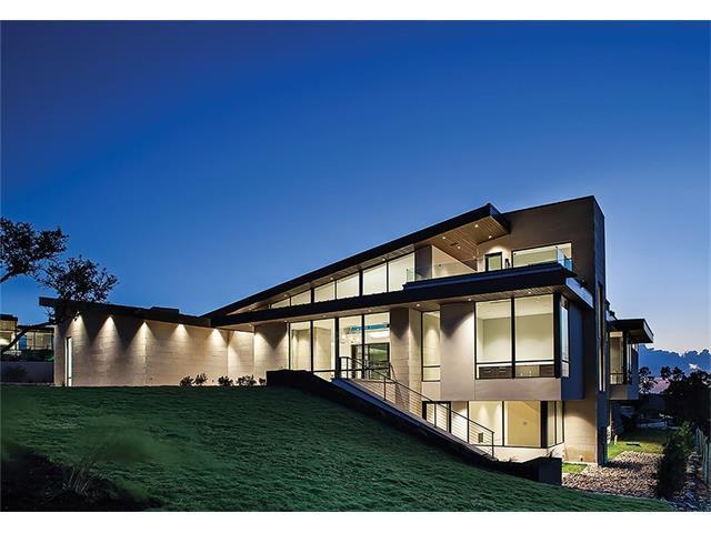Large contemporary at dusk with levels on hillside