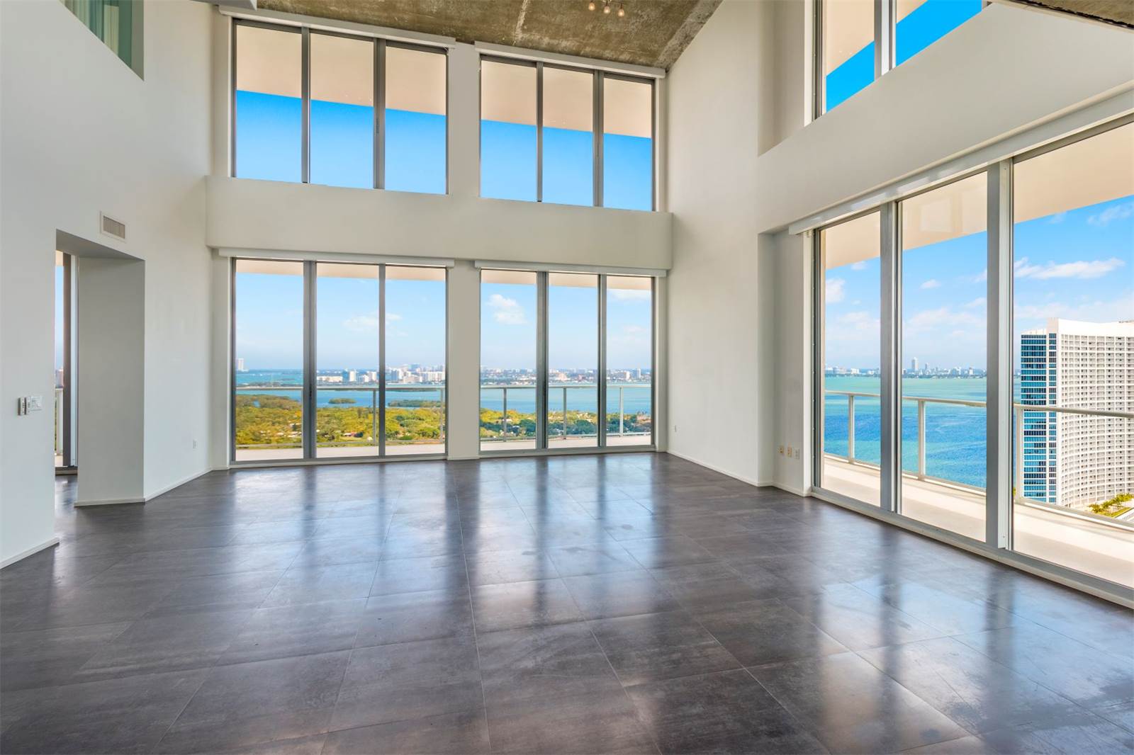 double-height ceilings in a midtown miami penthouse with bay views and floor-to-ceiling windows