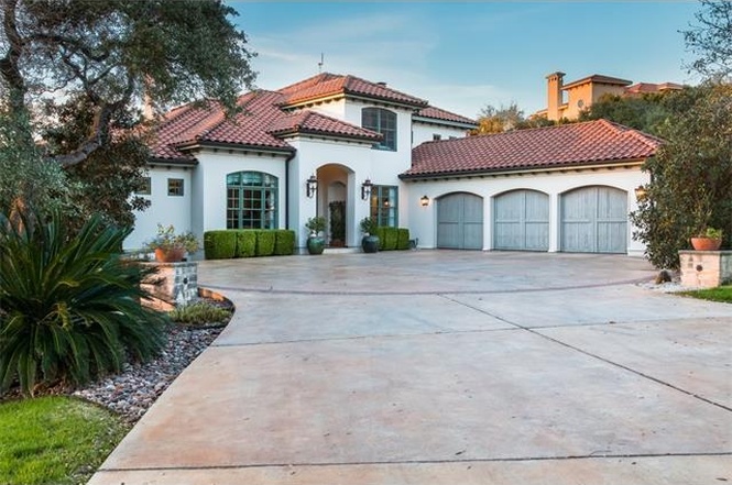 Large one-story white stucco home with ride tile roof