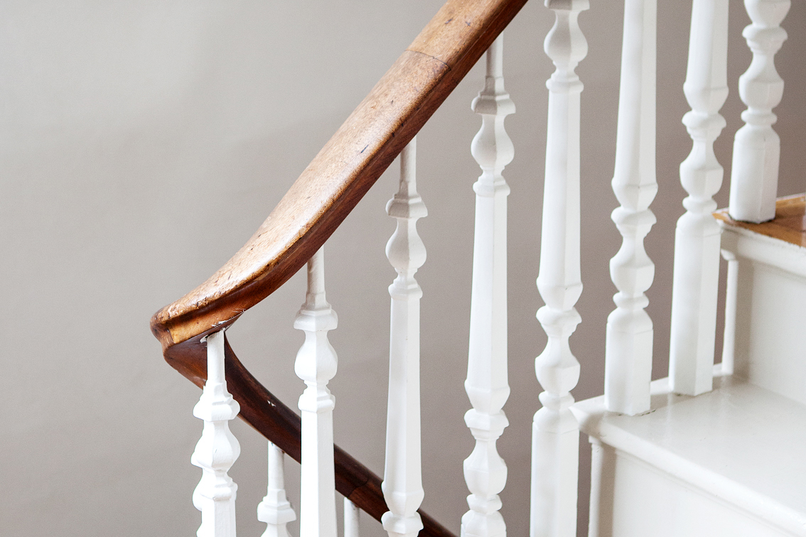 A tight shot of a wooden staircase, white and dark wood. 