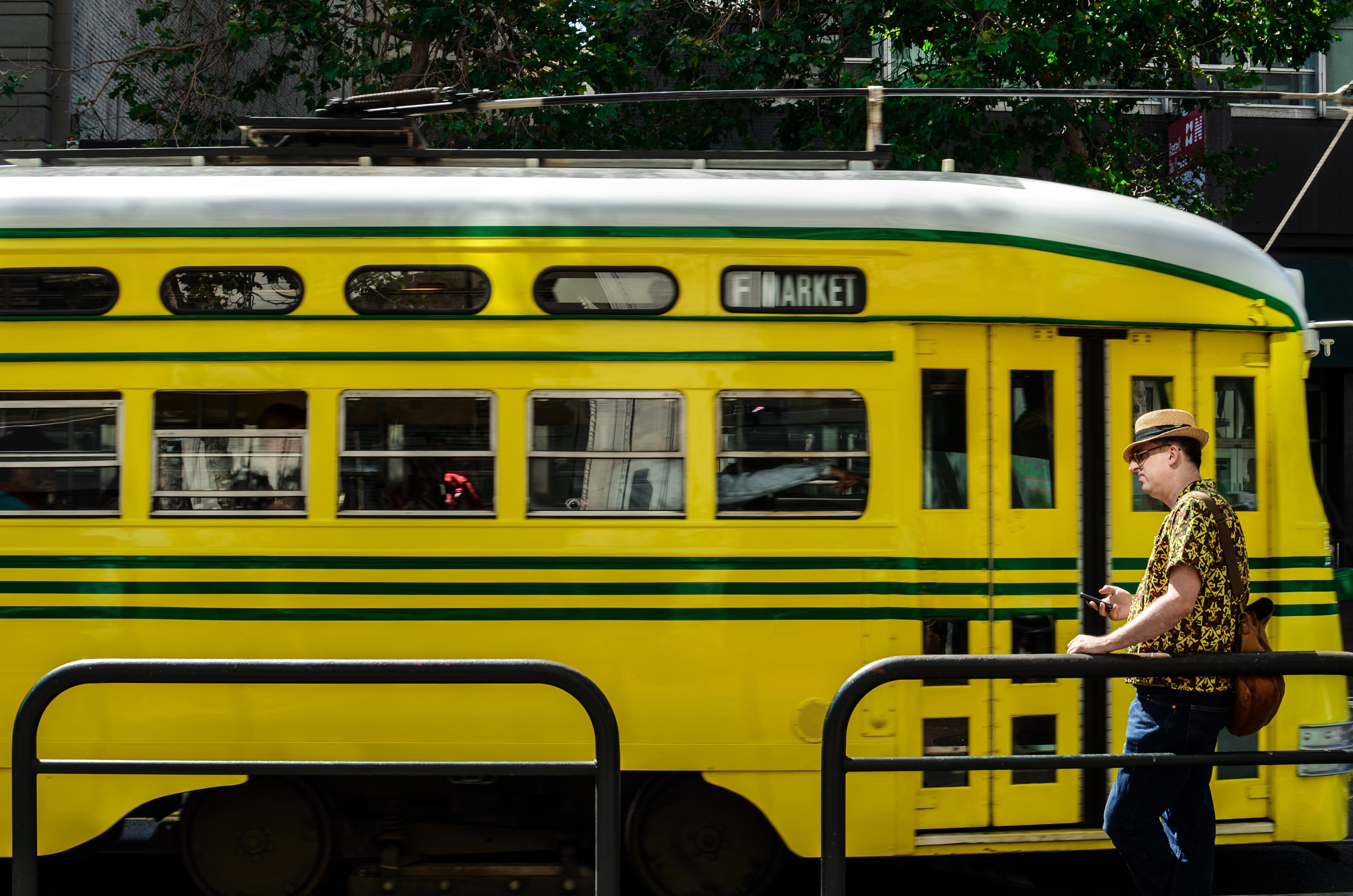 Streetcar on Market Street, yellow with green stripes. 