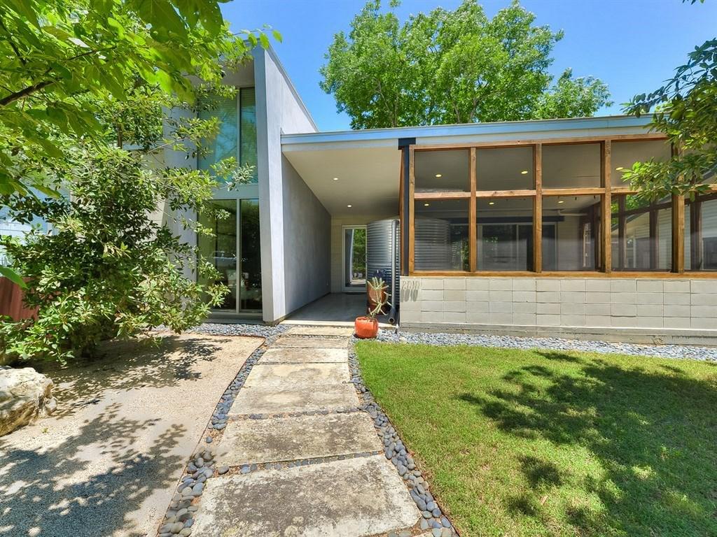 Rectangular modern/International-looking house with two wings, concrete, big window wall, tree