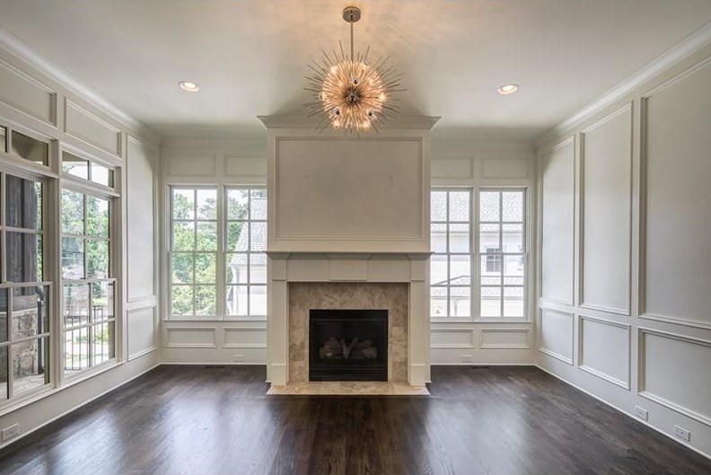 A great room with fireplace and sunburst light fixture.