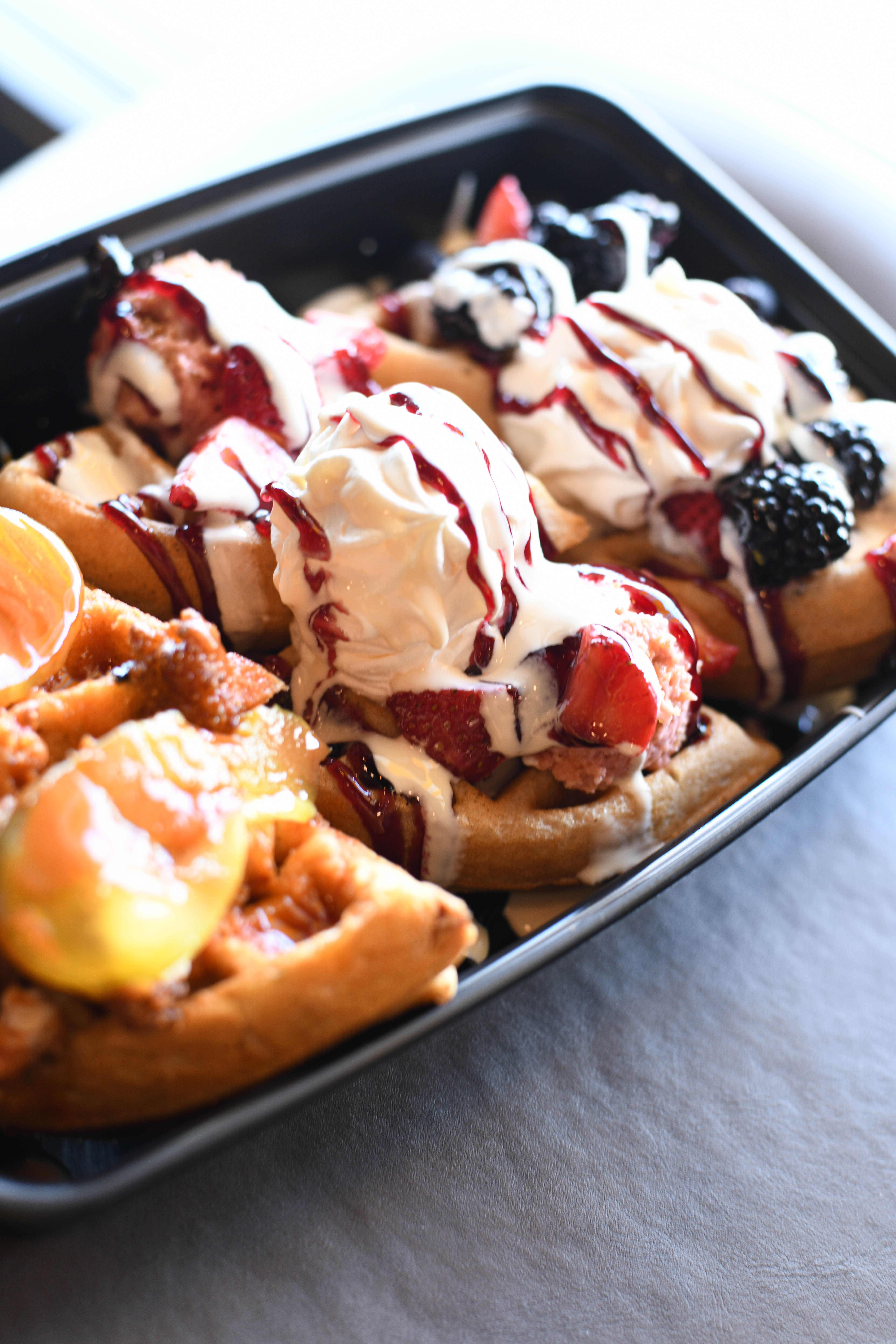 A flight of mini waffles topped with berries and fruit and cream from Waffle Cafe in Detroit, Michigan.