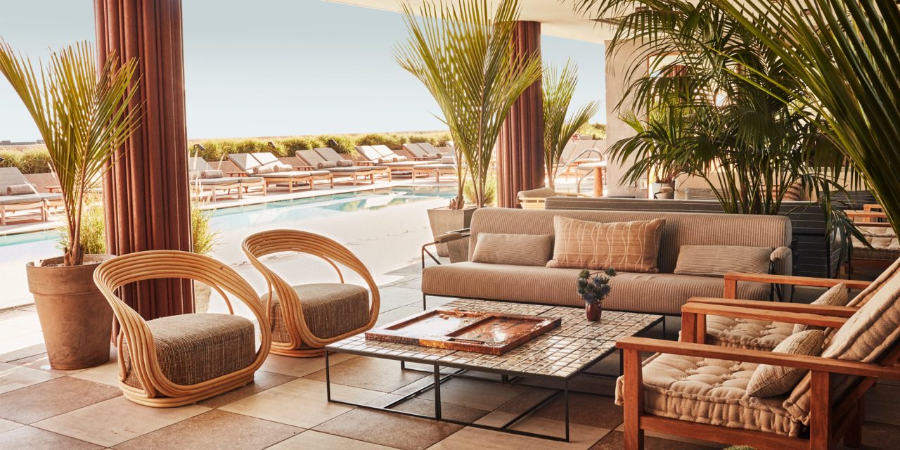 A mod, plush rooftop lounge area with throwback seating near a pool at summertime.