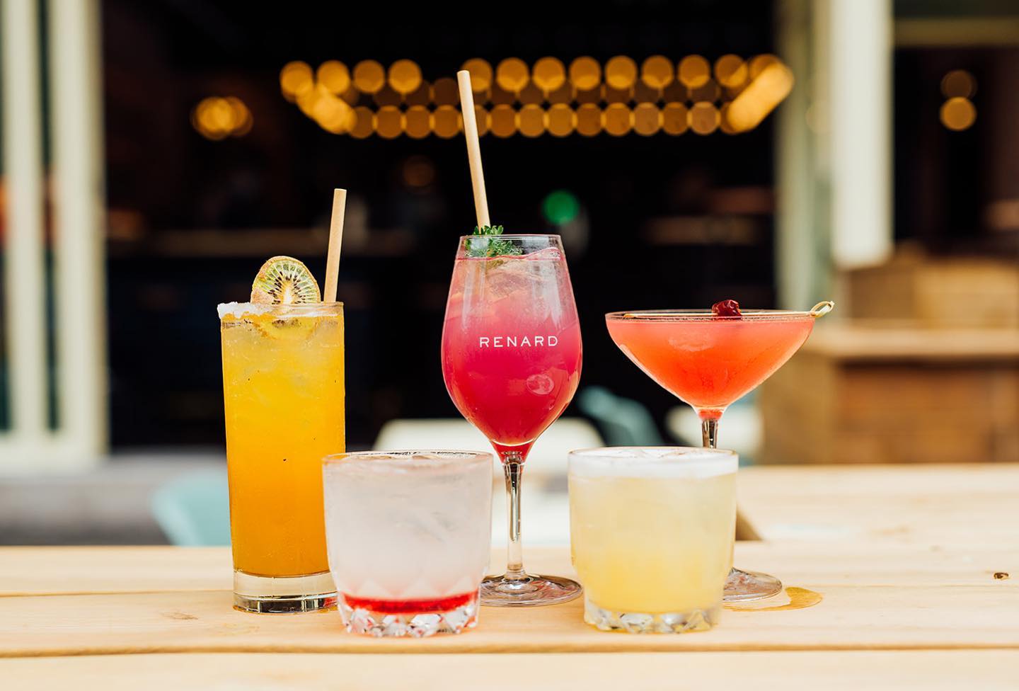 Five cocktails, including a pink one in the middle.