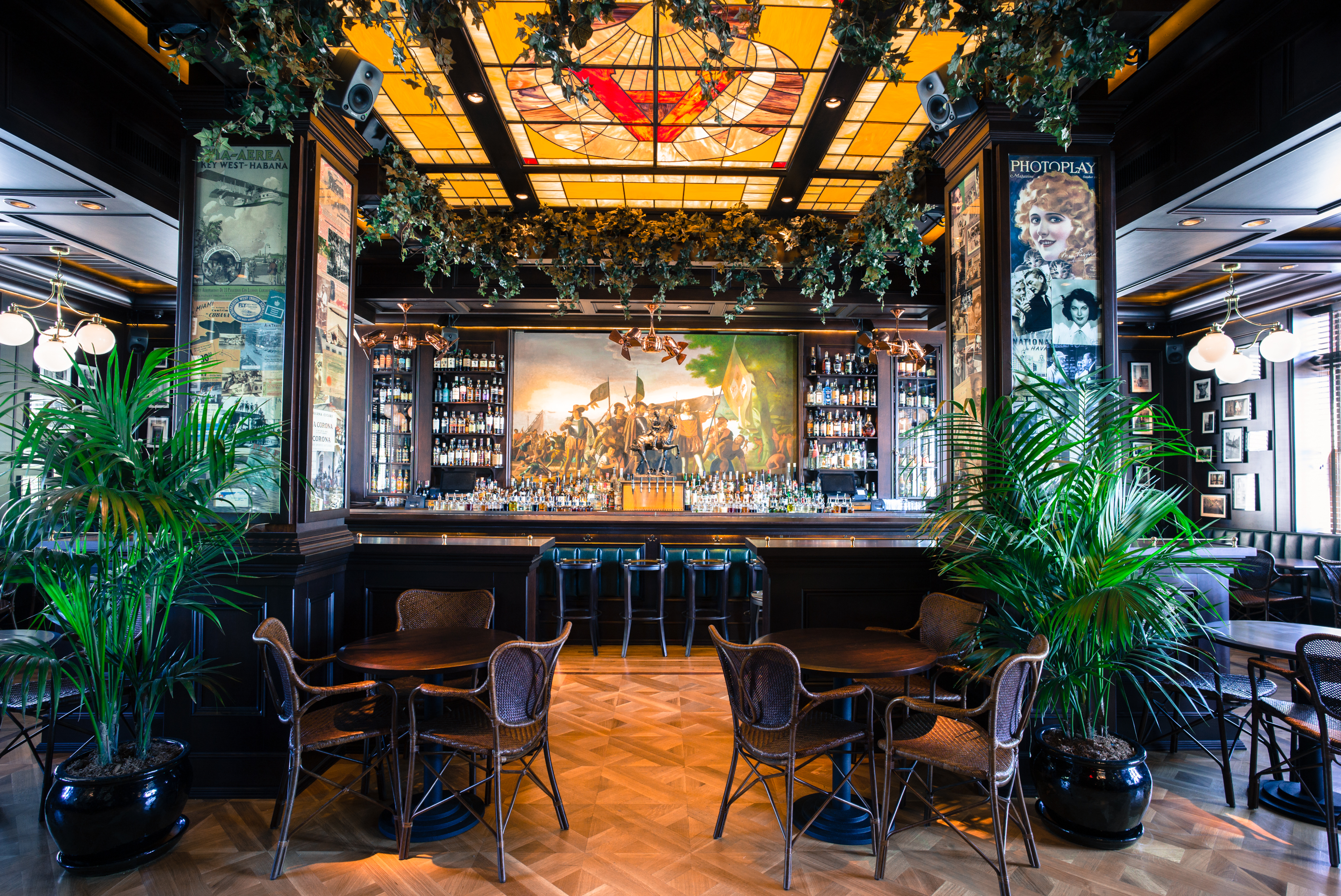 Blacktail’s dark bar, surrounded by two plants and a golden stained glass ceiling