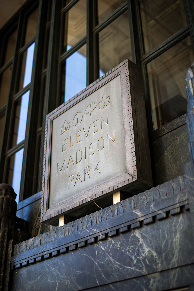 A stone sign announcing the entrance of Eleven Madison Park, a three-Michelin-starred vegan restaurant in Manhattan.