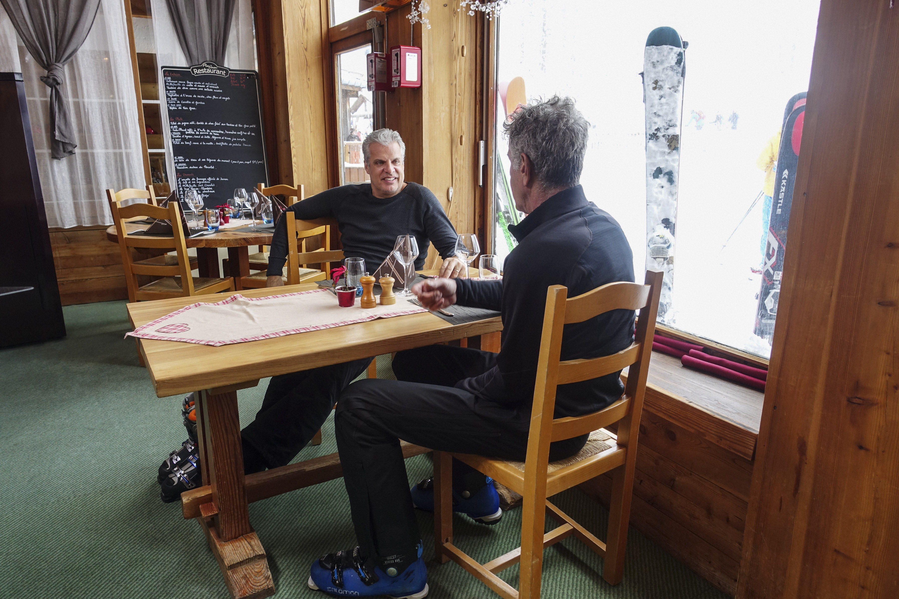 Eric Ripert and Anthony Bourdain sitting at a table during a scene from Parts Unknown.