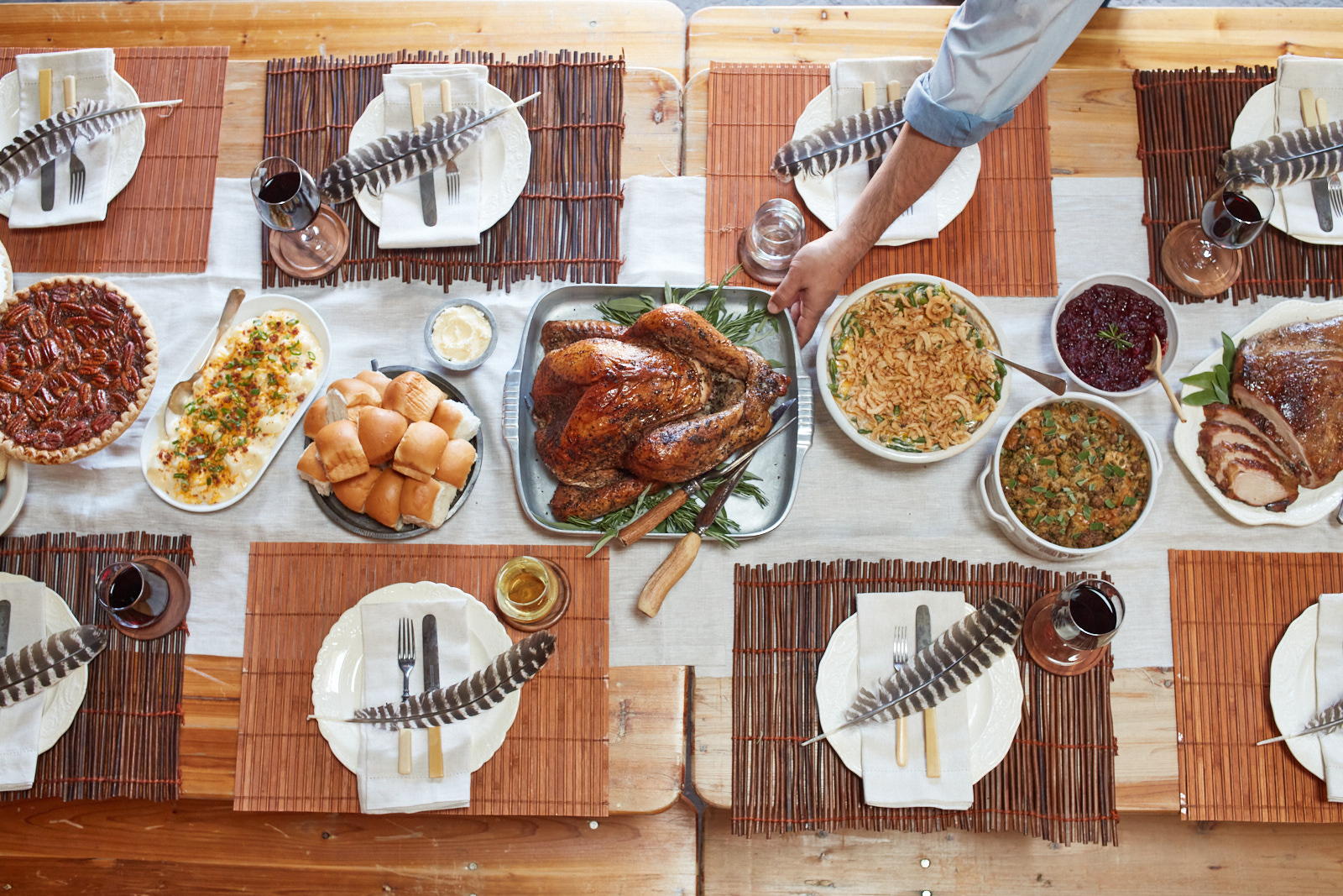 A man reaches for the turkey that sits in the middle of a Goode Company Thanksgiving spread.