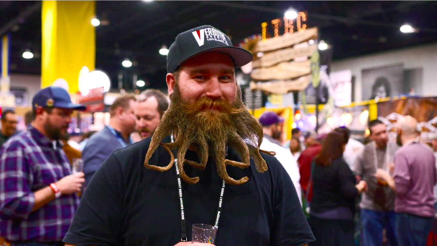 A man with a large beard styled to read “beer”.