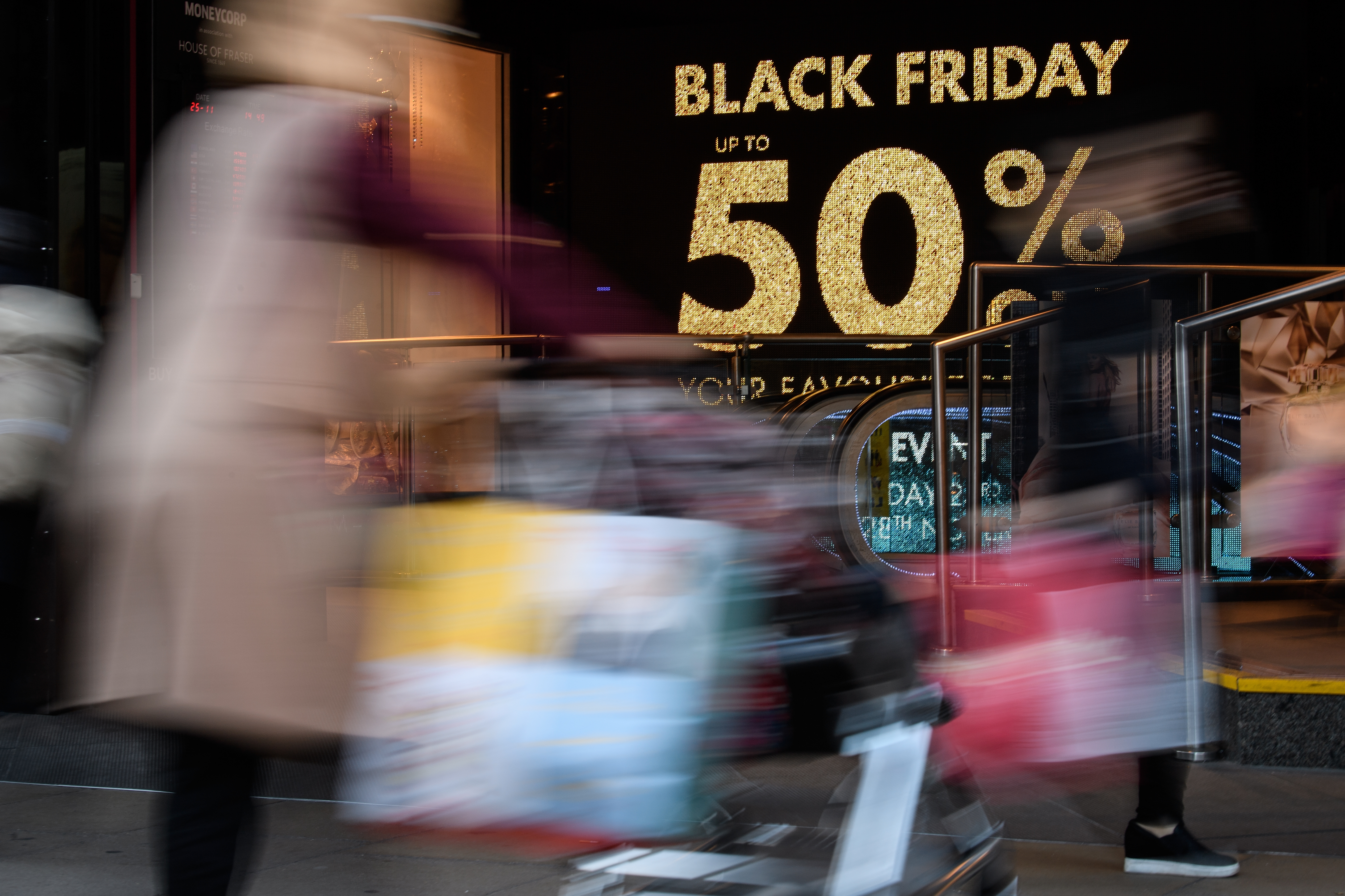 Shoppers carry their purchases on Oxford Street as stores offer discounted items in their "Black Friday" sales on November 25, 2016 in London, England