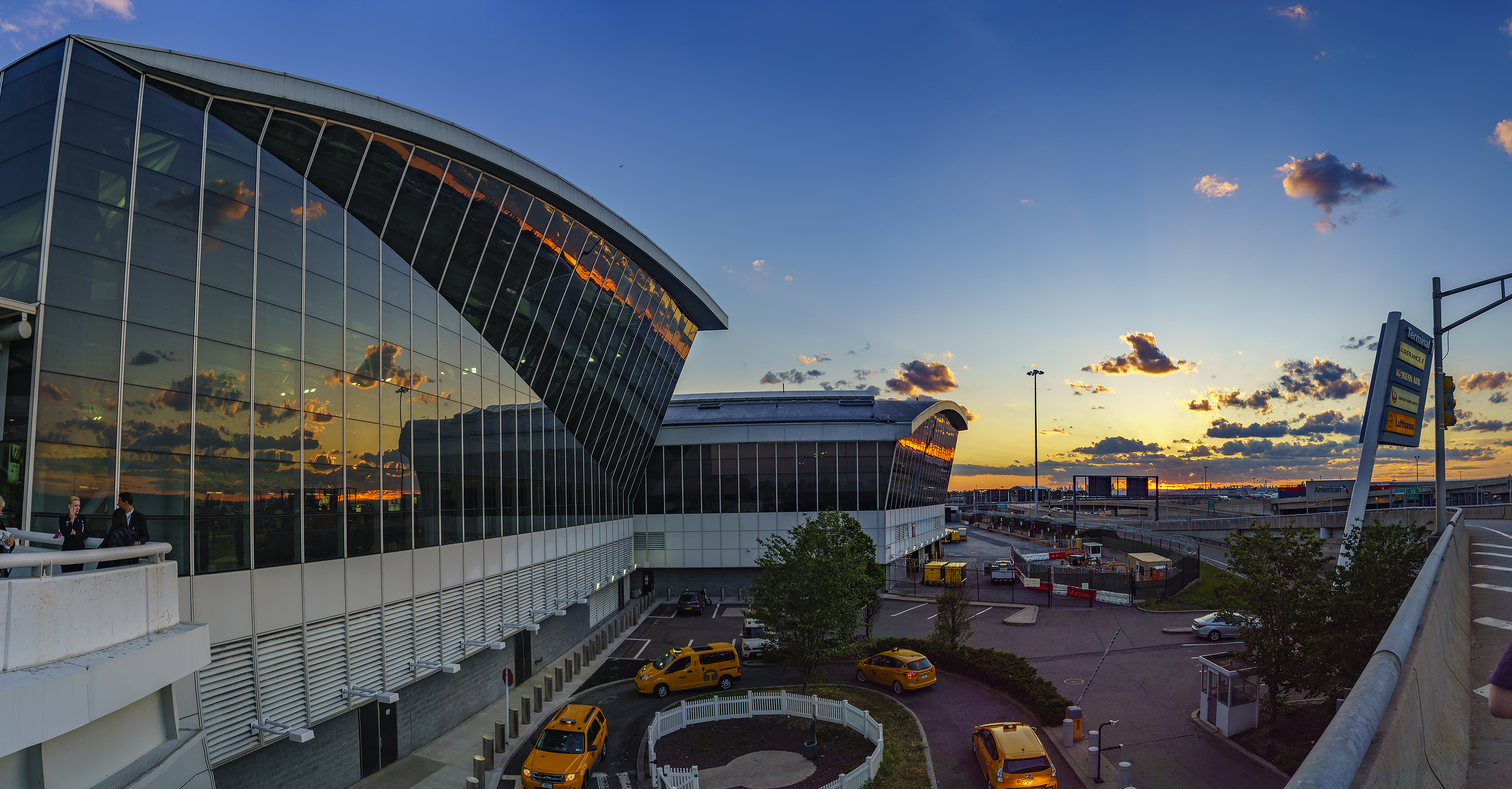 An exterior view of JFK airport with the sun setting in the background.