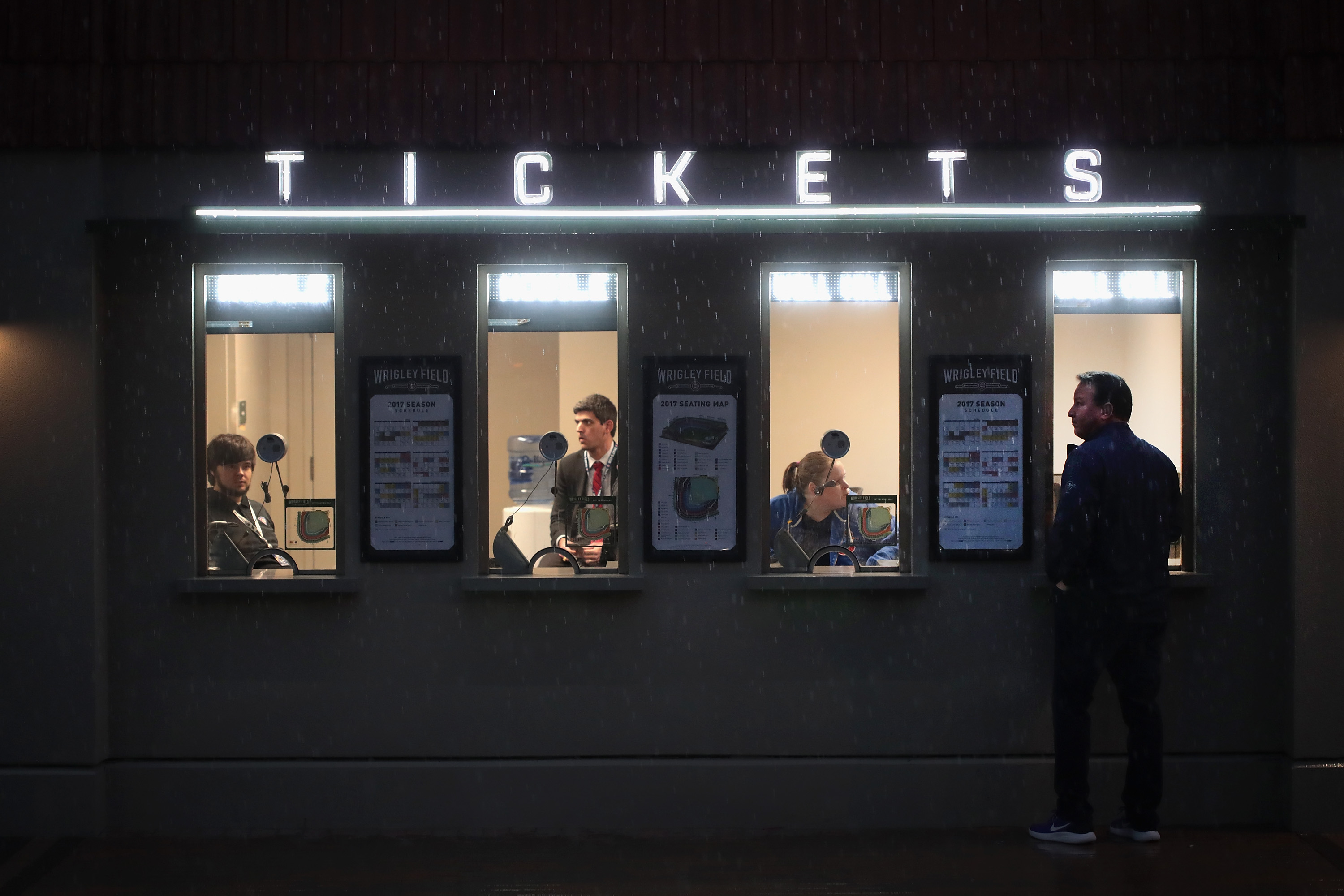 CHICAGO, IL - APRIL 10:  A fan stands at the ticket window in the rain outside of Wrigley Field before the start of the 2017 home opener against the Los Angeles Dodgers on April 10, 2017 in Chicago, Illinois. The Cubs defeated the Cleveland Indians in seven games to win the 2016 World Series.  (Photo by Scott Olson/Getty Images)