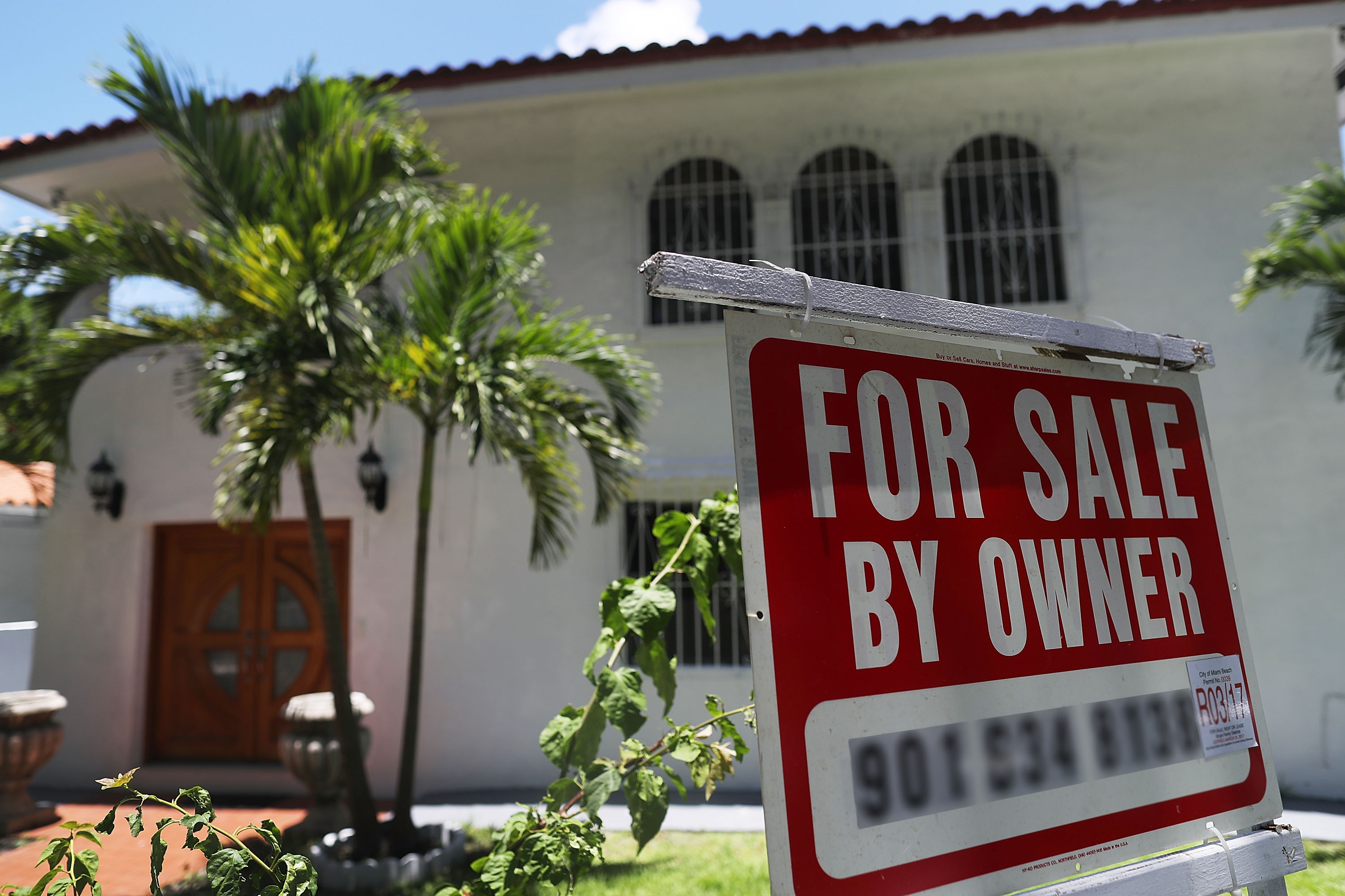 A for-sale sign is seen in front of a home in Miami, 