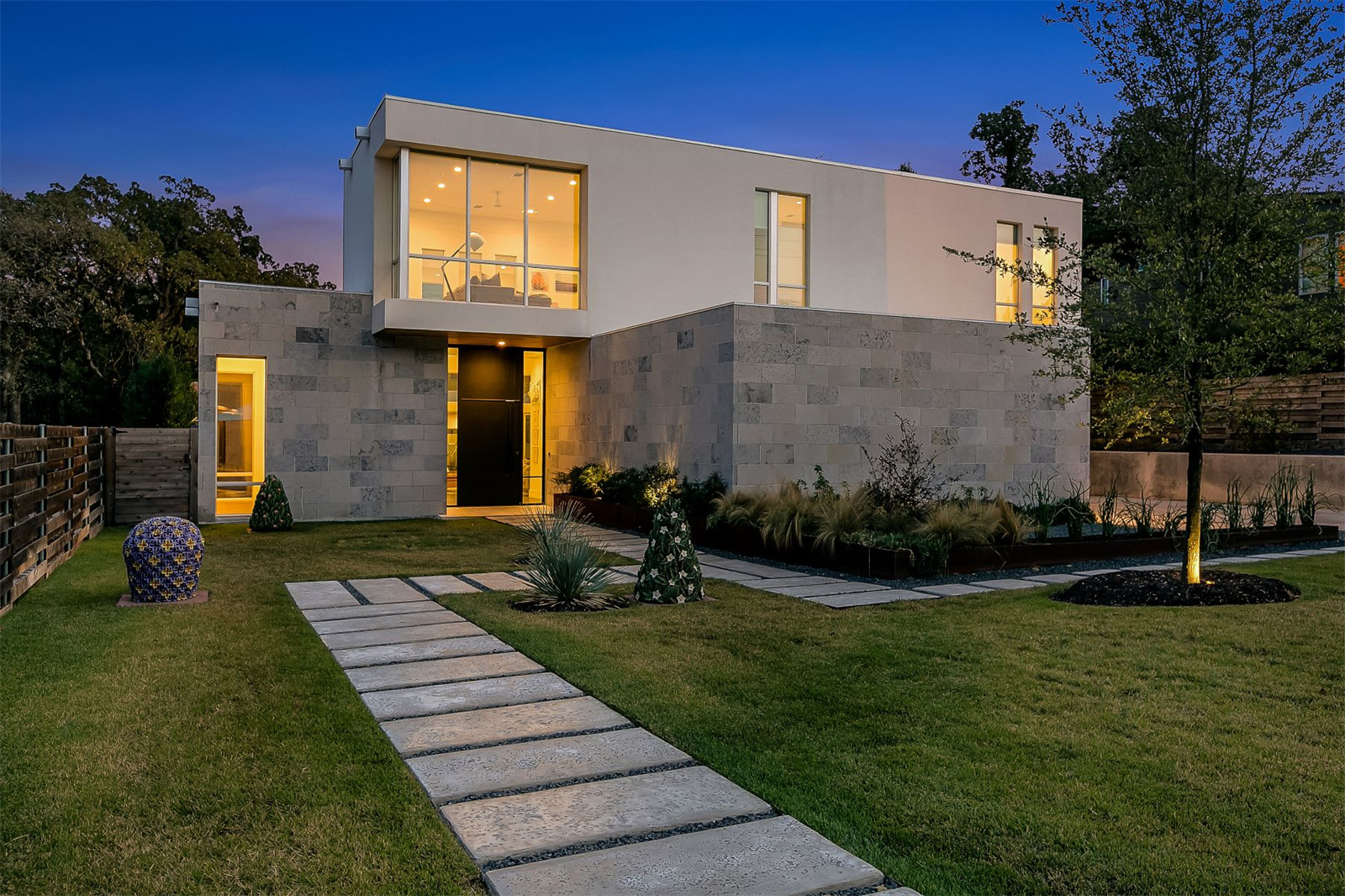 Blocky stucco-and-concrete home with lawn in from