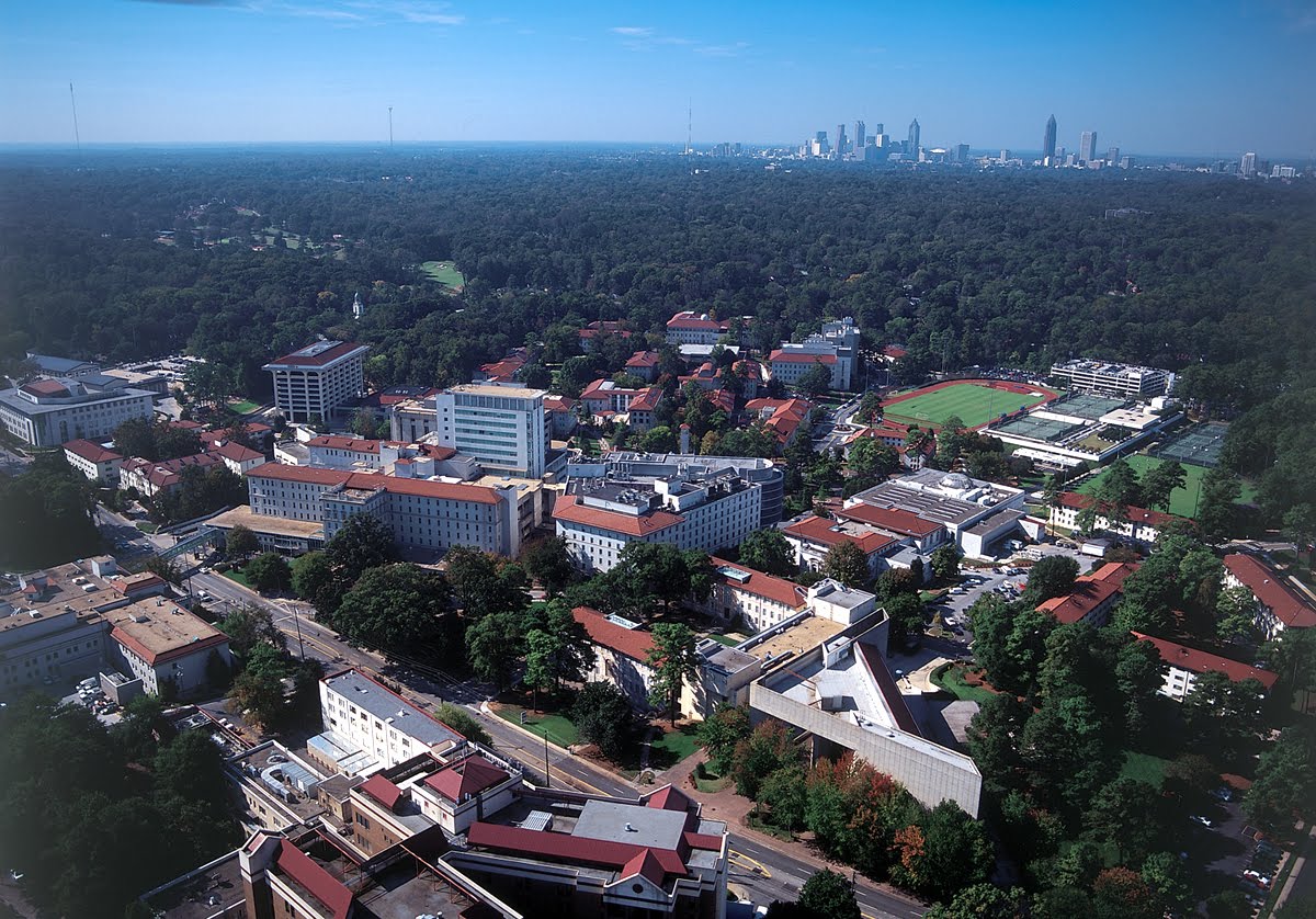 An aerial view of the campus with forests and the skyline beyond.