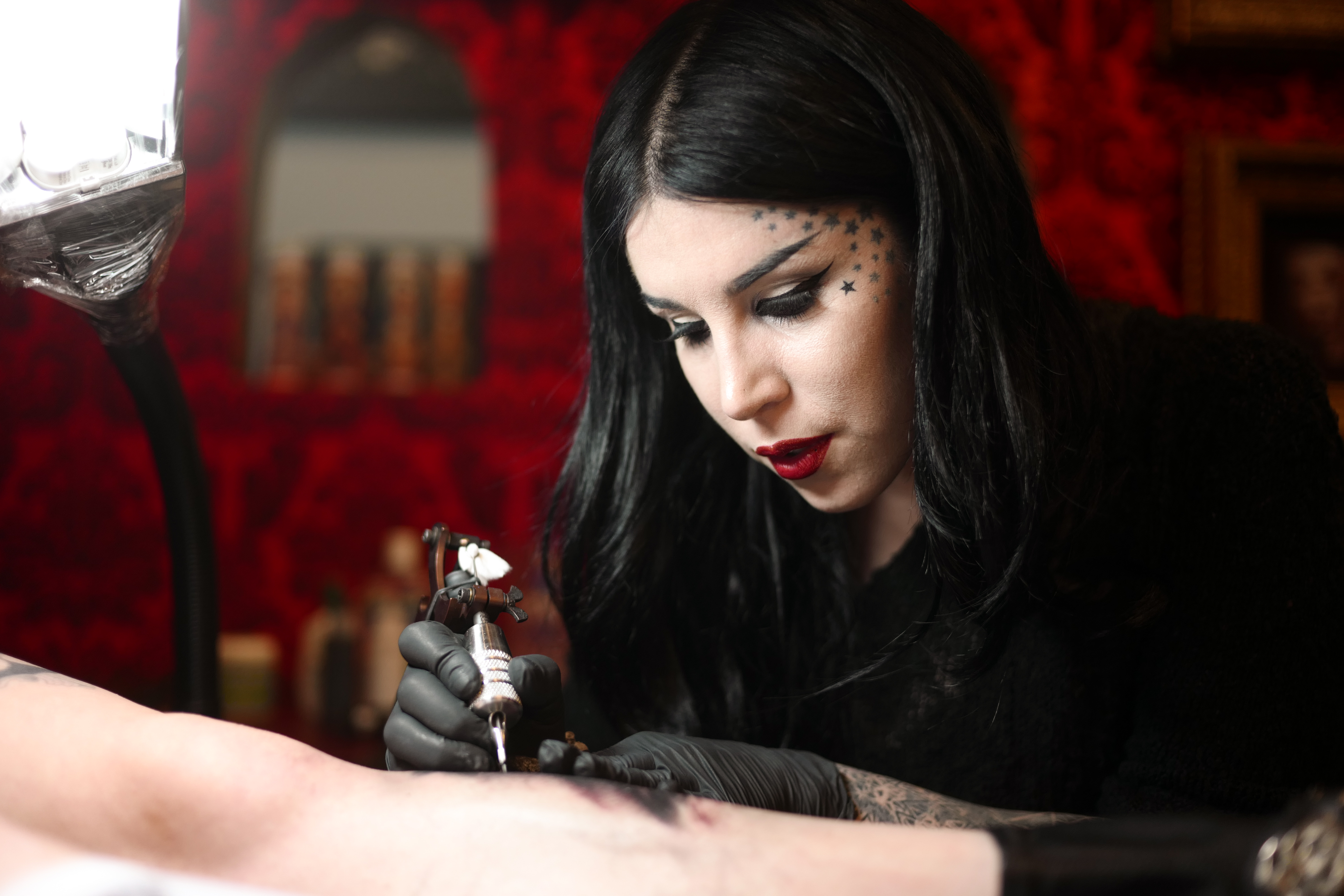 Kat Von D tattoos a person’s arm at her West Hollywood tattoo studio.