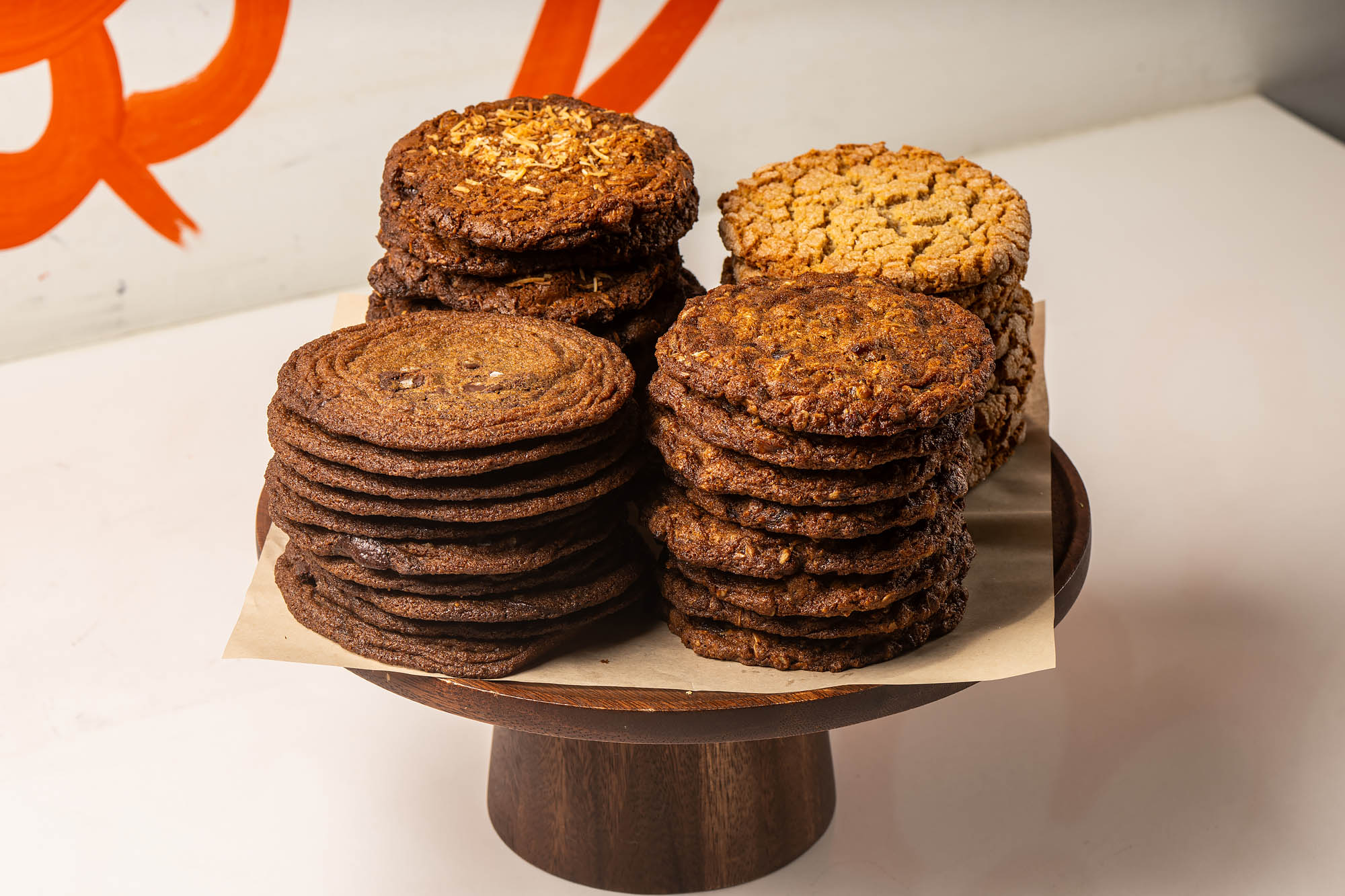 A round wooden elevated tray of stacks of different kinds of dark cookies at Friends &amp; Family bakery in Los Angeles.