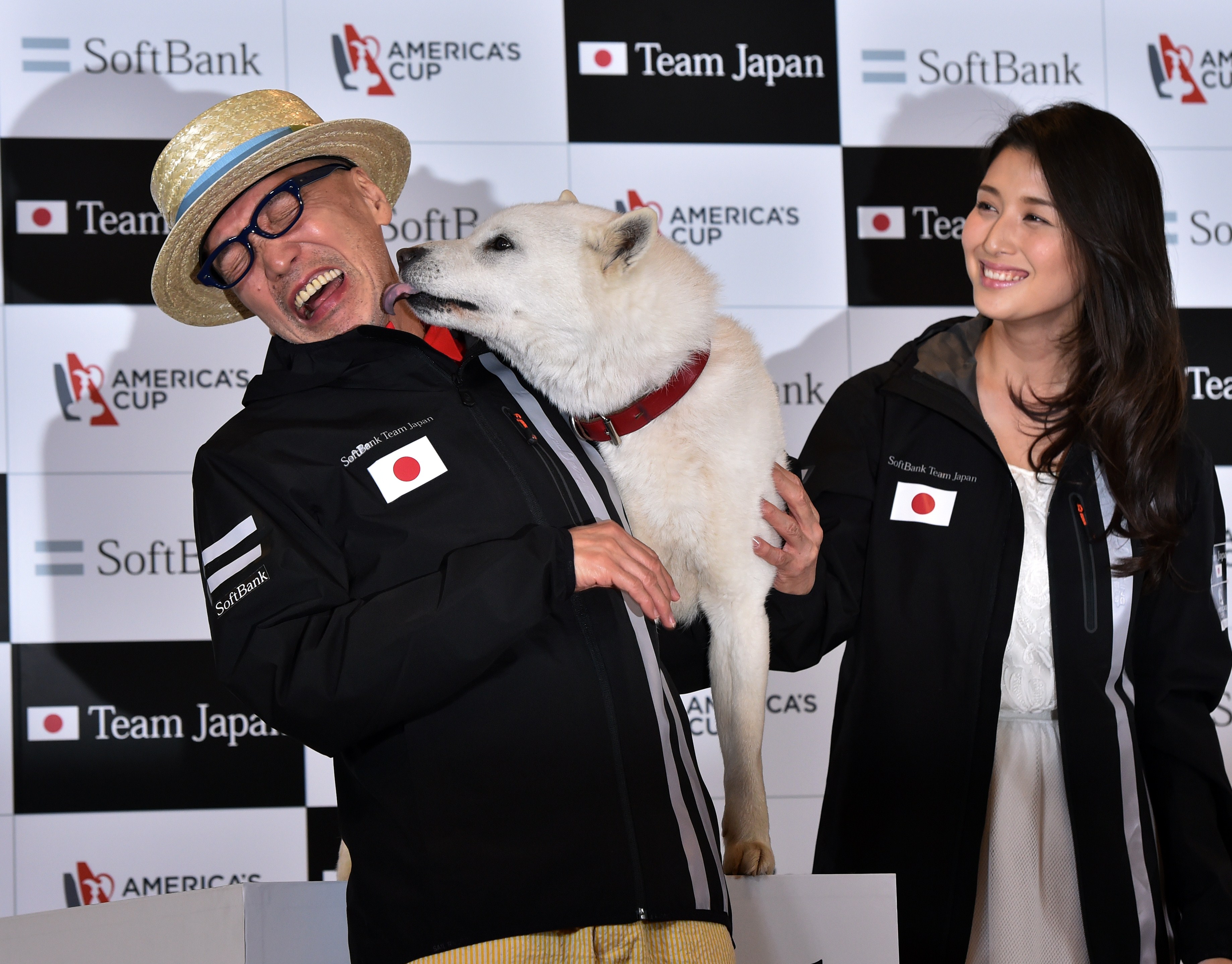 TV commentator Terry Ito is licked by SoftBank’s dog mascot.