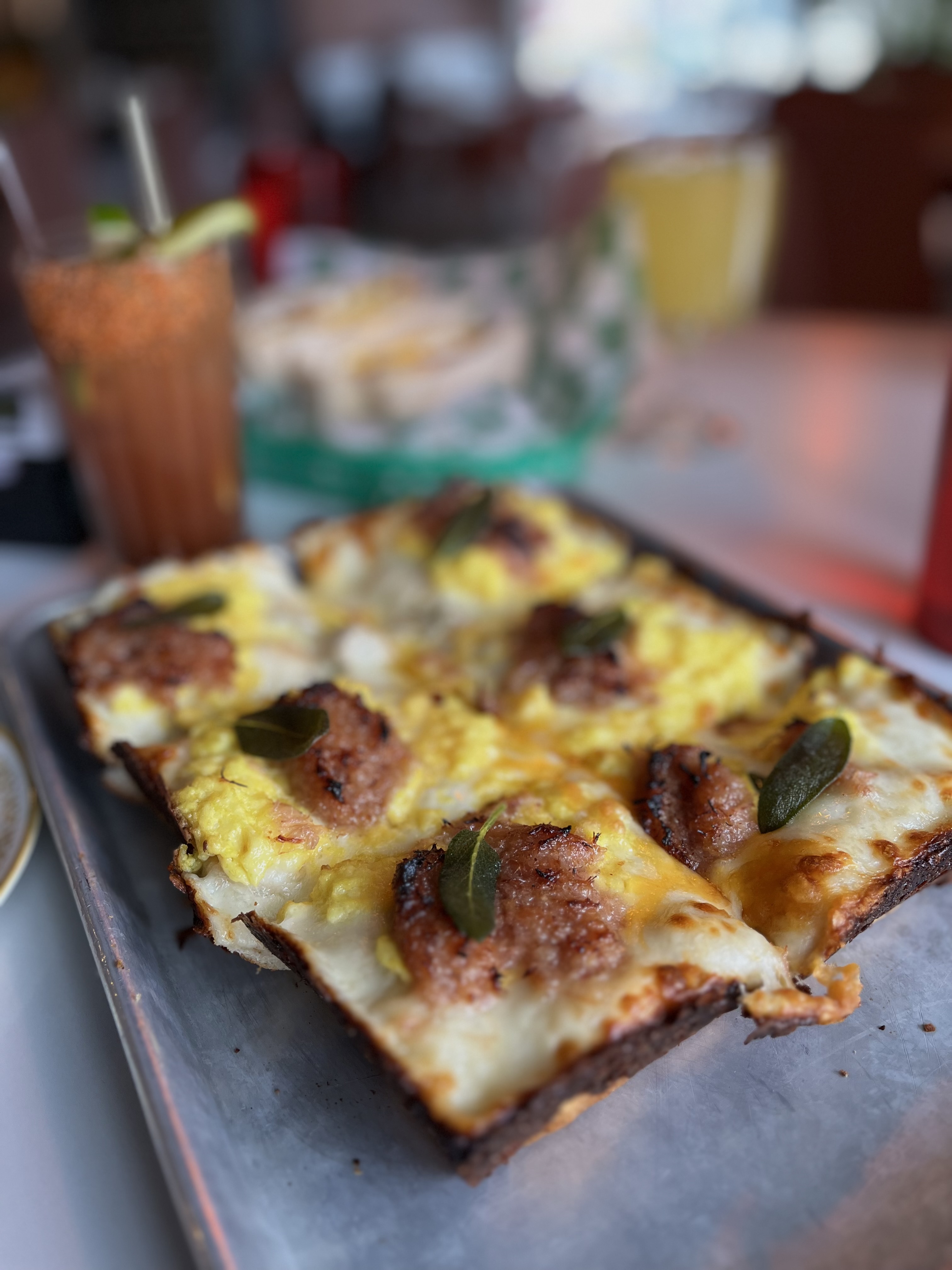 A rectangular Detroit-style pizza topped with ricotta and meatballs. 