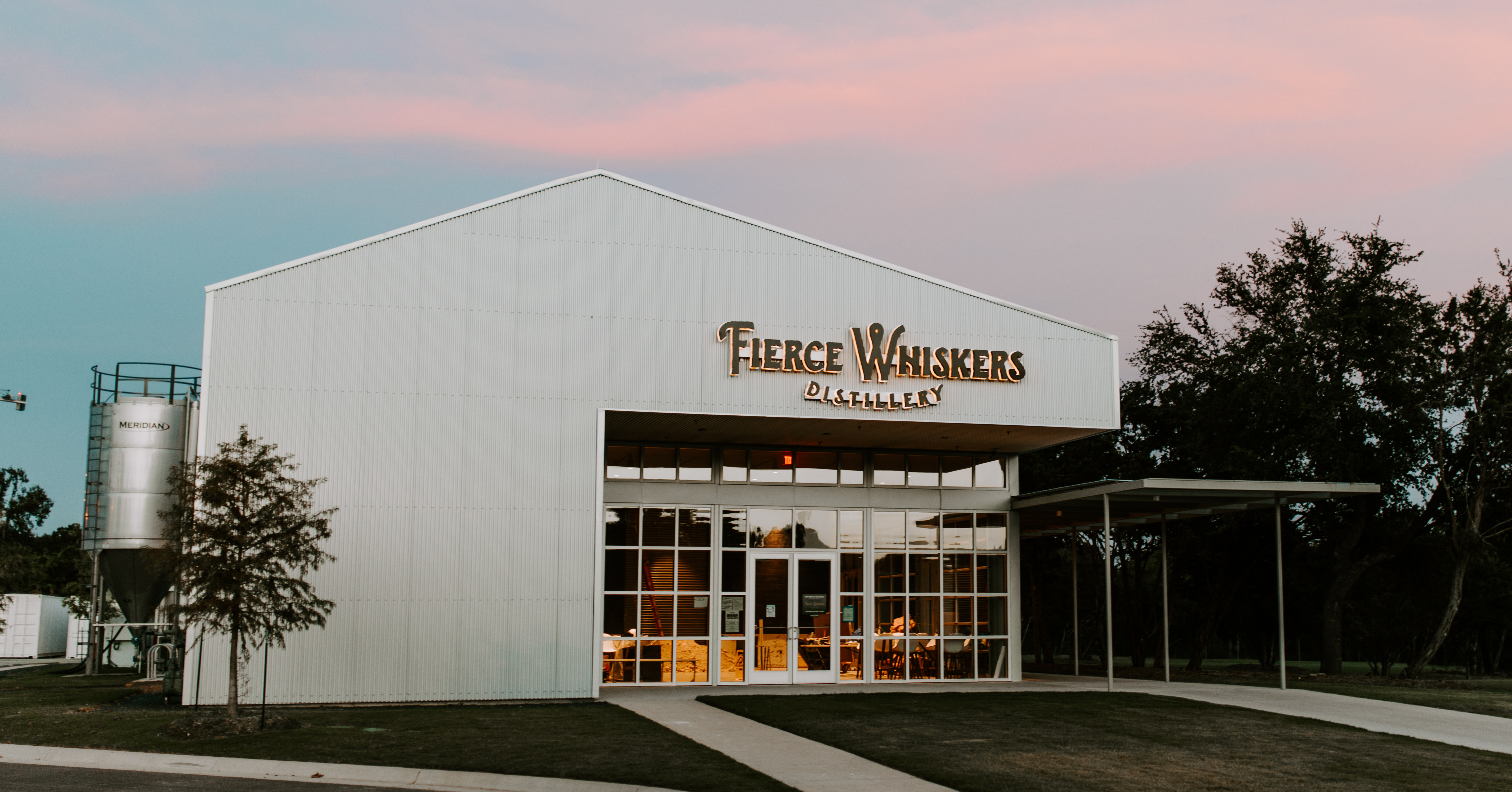 White building with Fierce Whiskers sign against a pretty sunset
