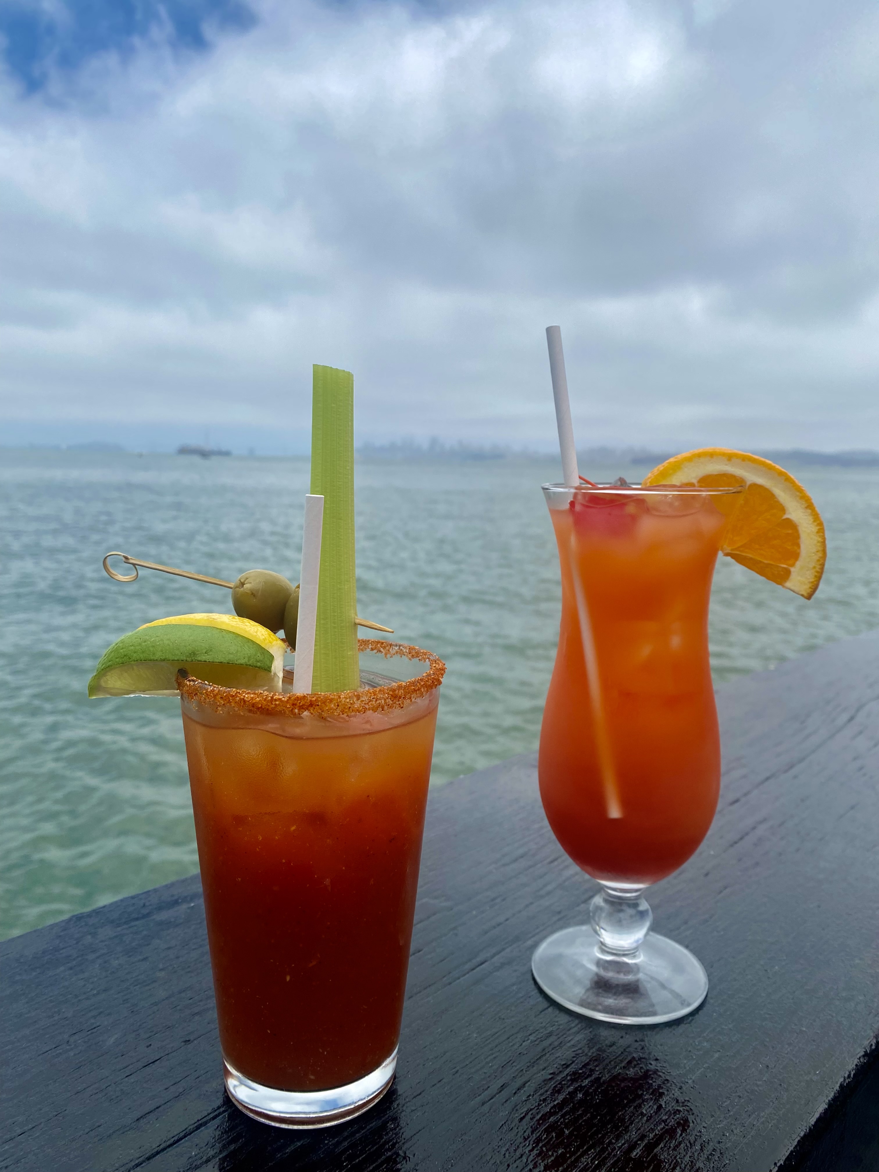 Two cocktails in front of the ocean.