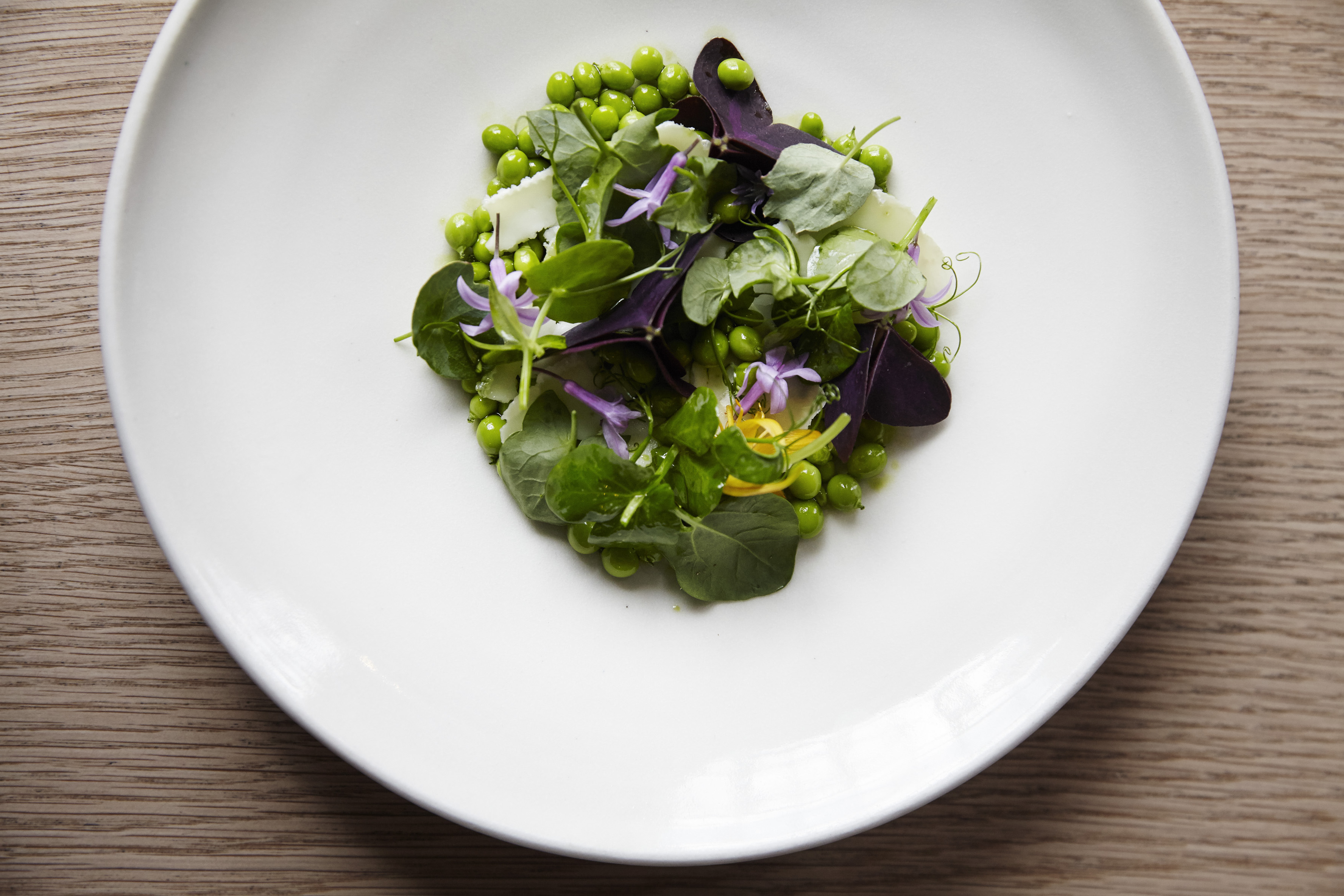 A plate of peas and pea shoots.