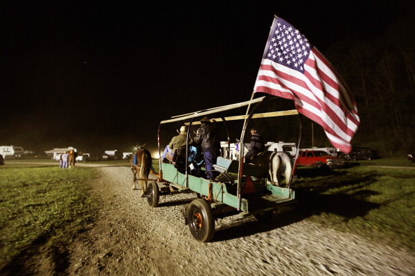 Riders pass in a wagon with an American flag at the Owsley County Saddle Club trail ride on April 19, 2012 in Booneville, Kentucky. The 2010 U.S. Census listed Owsley County as having the lowest median household income in the country outside of Puerto Ric