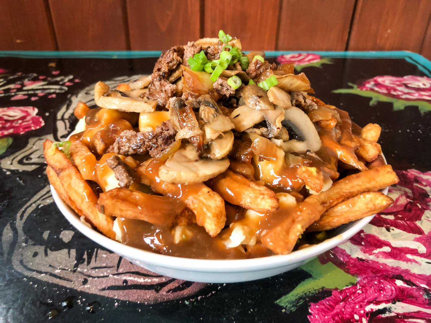 Poutine with some additional toppings such as mushrooms.