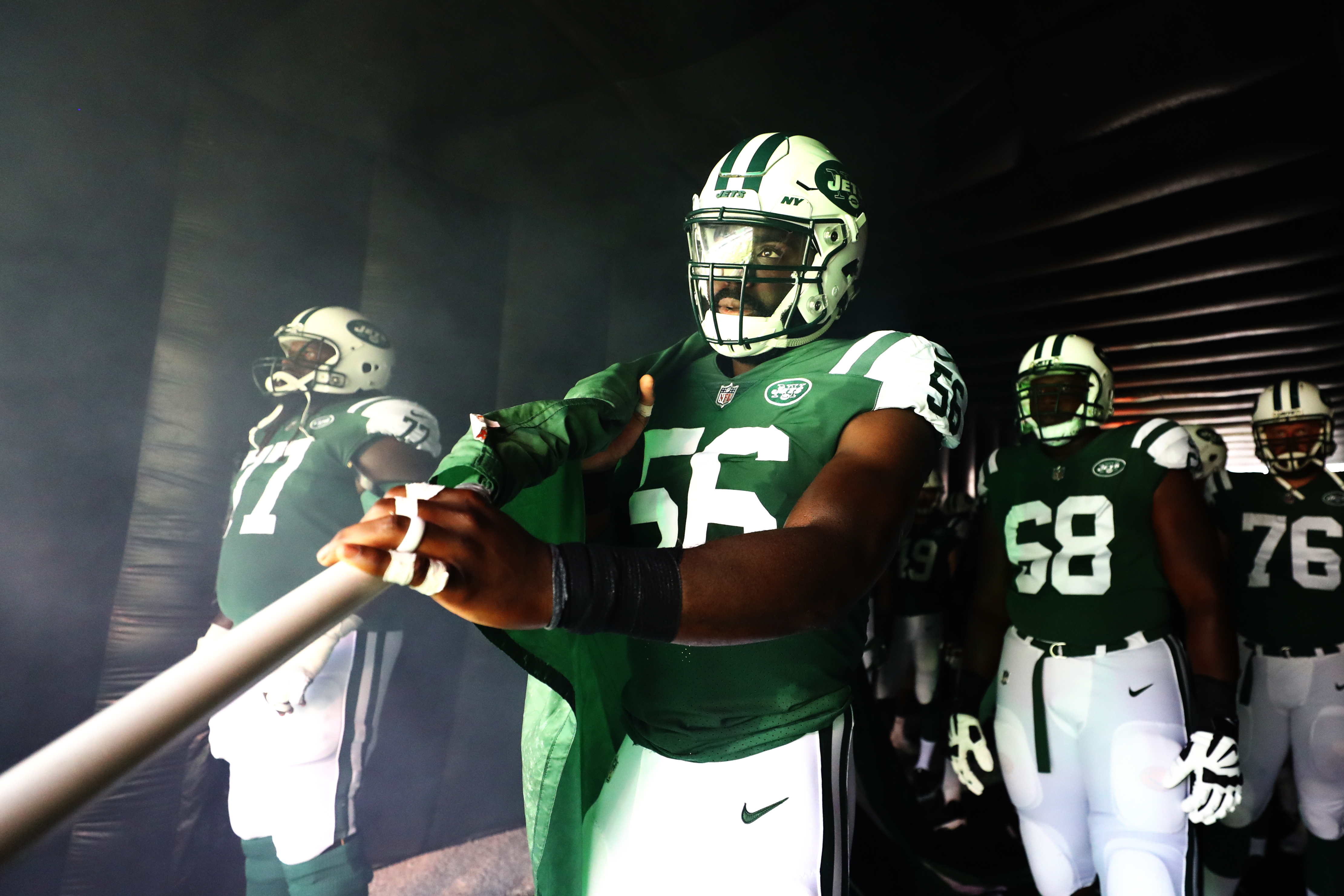 EAST RUTHERFORD, NJ - New York Jets linebacker Demario Davis (56) prepares to carry the team flag out onto the field during pregame ceremonies before a regular season contest against the Miami Dolphins at MetLife Stadium.