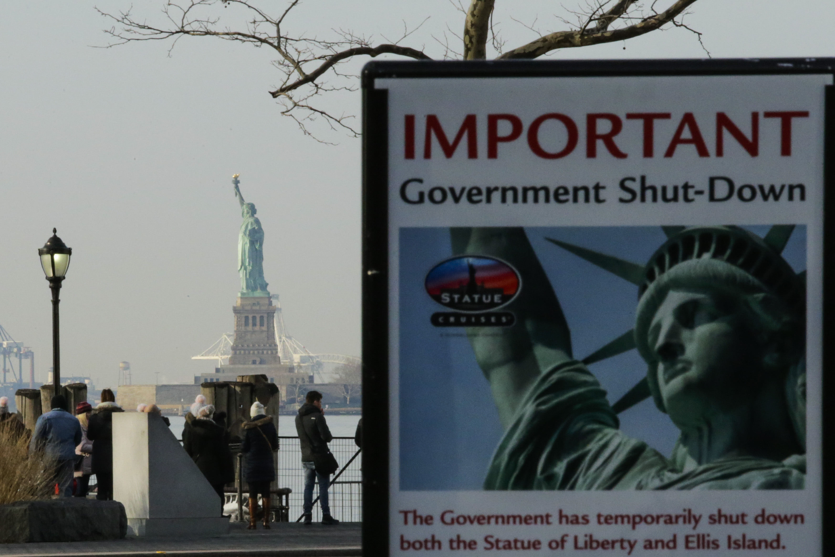 A sign reading “IMPORTANT: Government shut-down.” In the background is the Statue of Liberty.