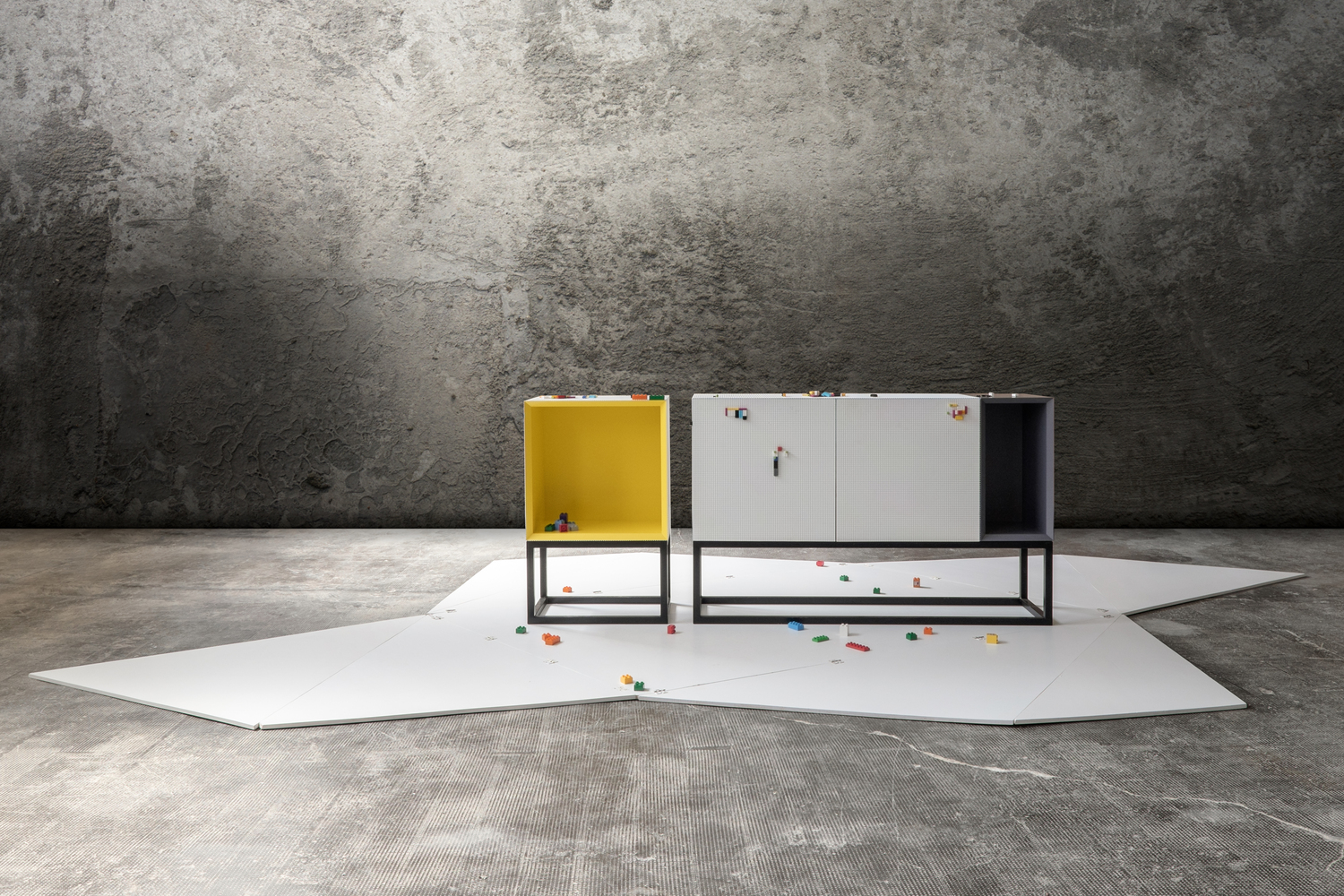 Simple boxy furniture on steel legs feature studded surface compatible with Lego blocks. 