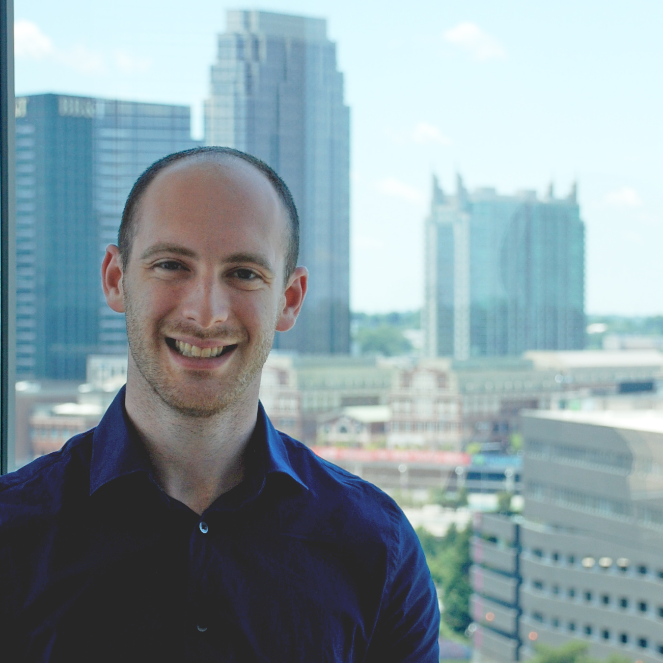 A hideous, ghastly headshot with the skyline of Atlantic Station in the background.